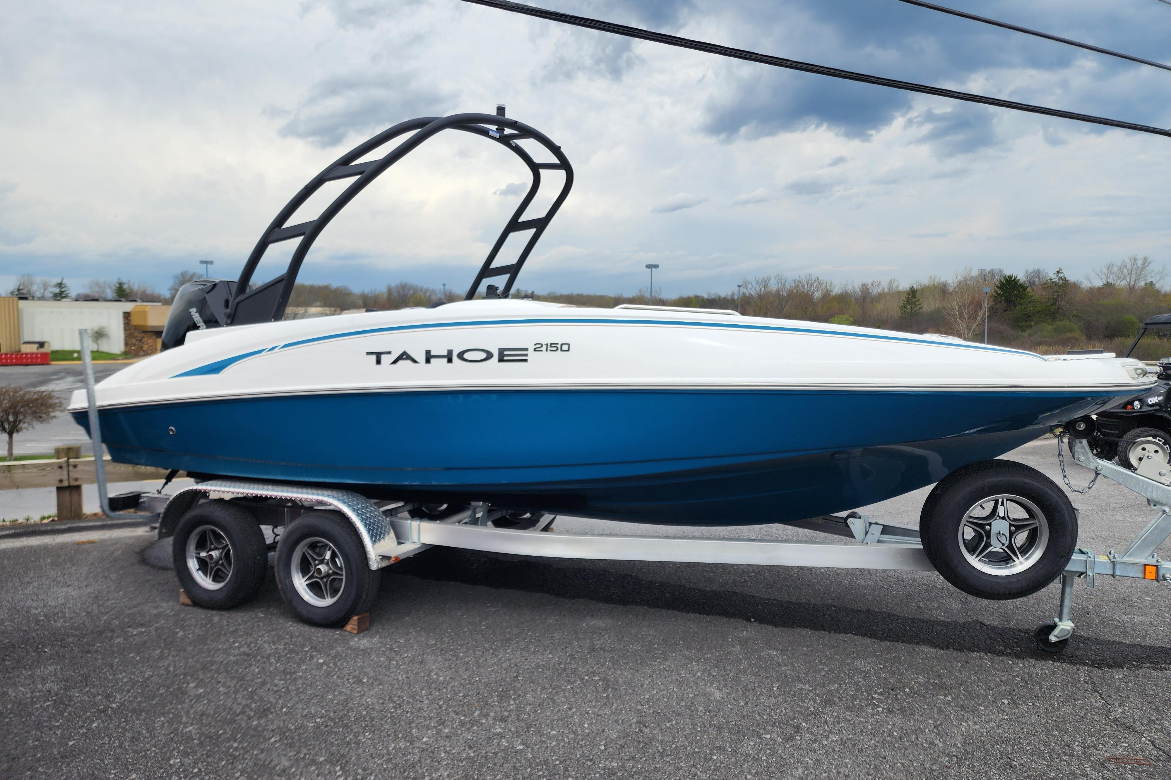 2026 Tahoe 2150 boat on trailer, blue and white design, parked outdoors.