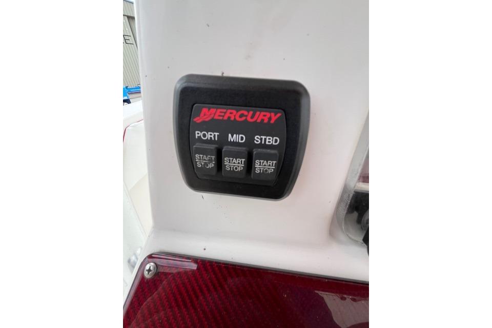 Control panel of a 2001 Fountain 38 Center Console boat with Mercury start/stop buttons.