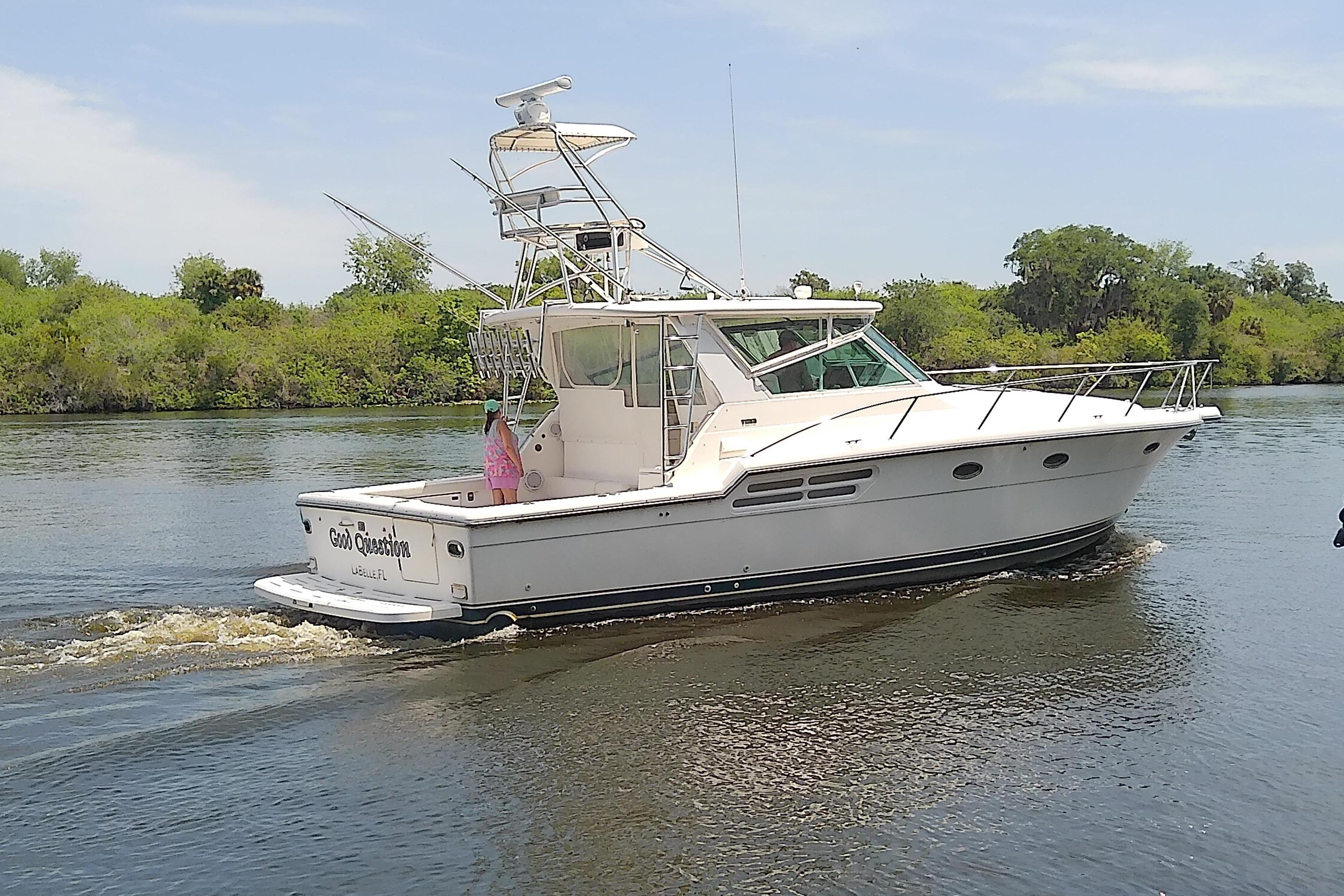 2000 Tiara Yachts 4100 Open cruising on a calm river with lush greenery.