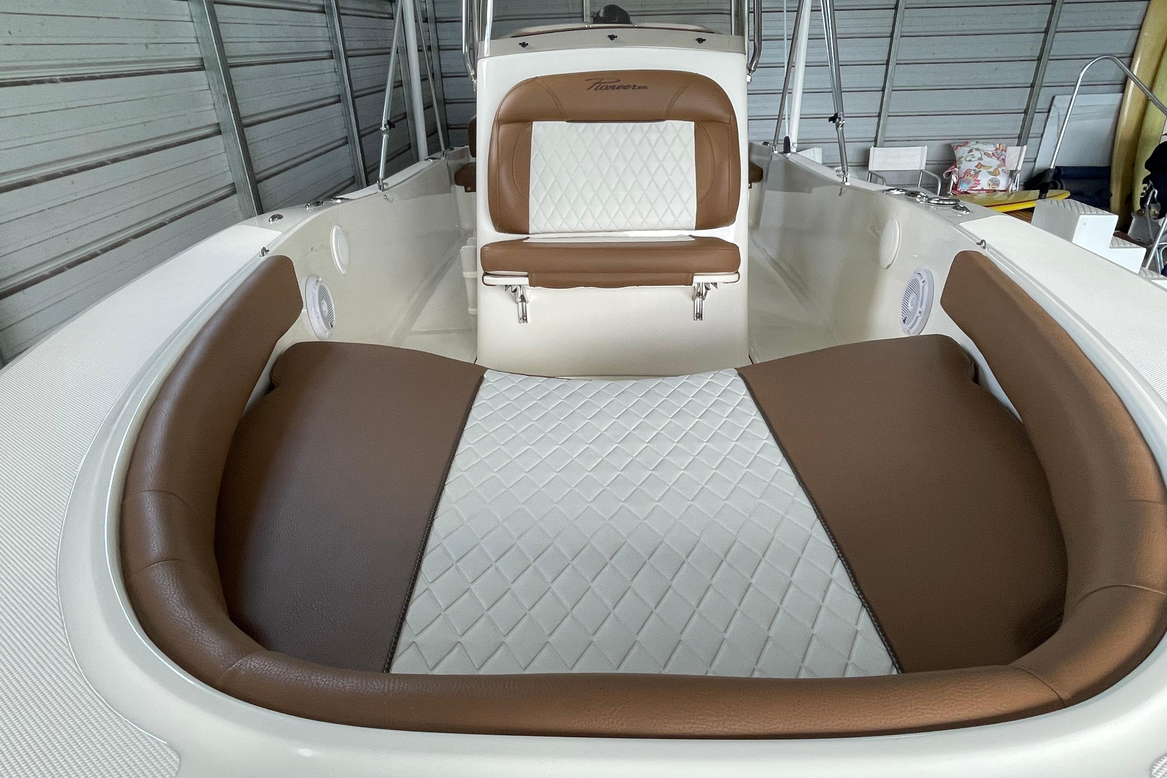2024 Pioneer 180 Islander boat interior with brown and white cushioned seating.