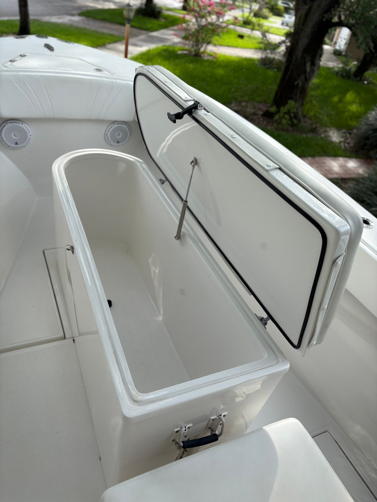 An open storage compartment on a boat with white upholstery.
