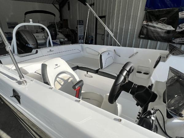2025 Stingray 172SC boat interior with white seating and steering wheel in showroom.