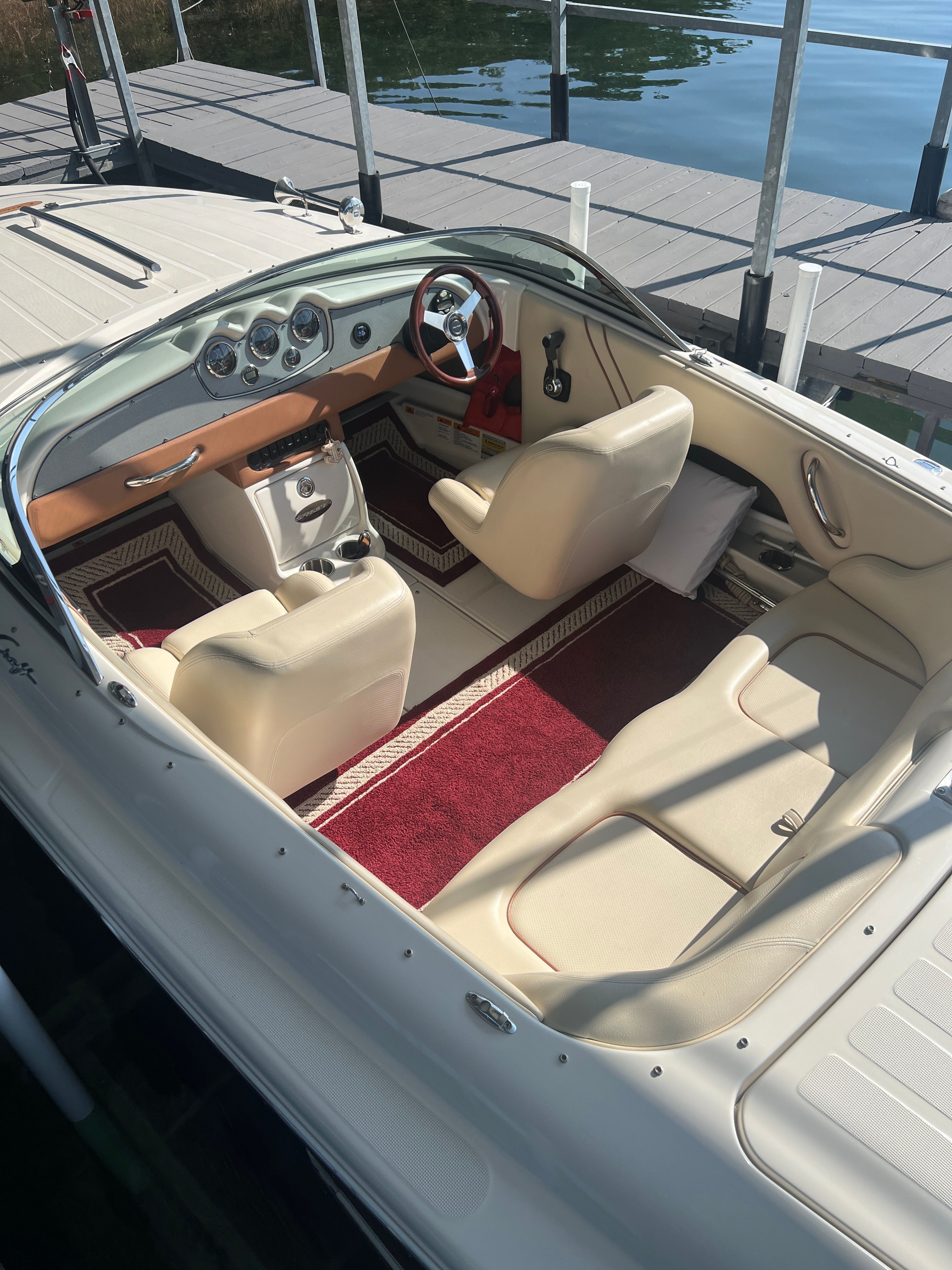 Interior view of a 2006 Chris-Craft Speedster 20 with cream seats and red carpet.