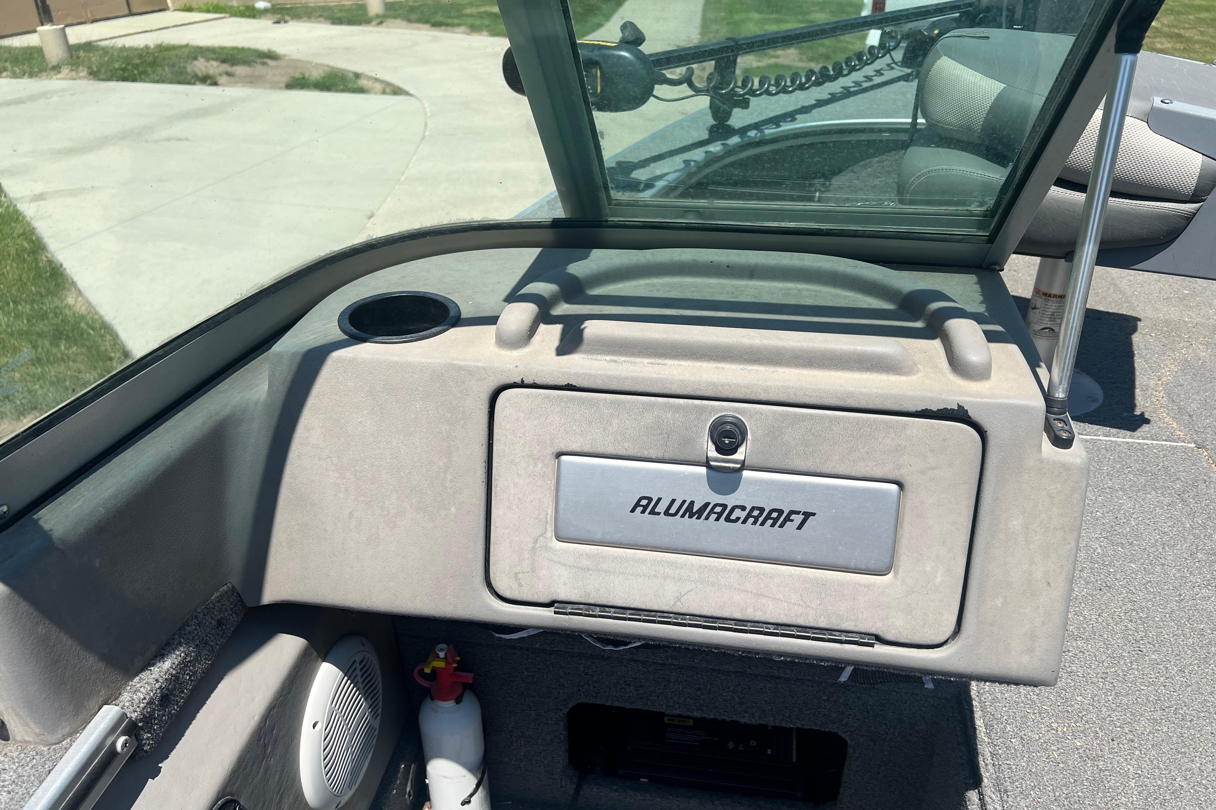 2010 Alumacraft Dominator 165 Sport boat interior with storage compartment and windshield.