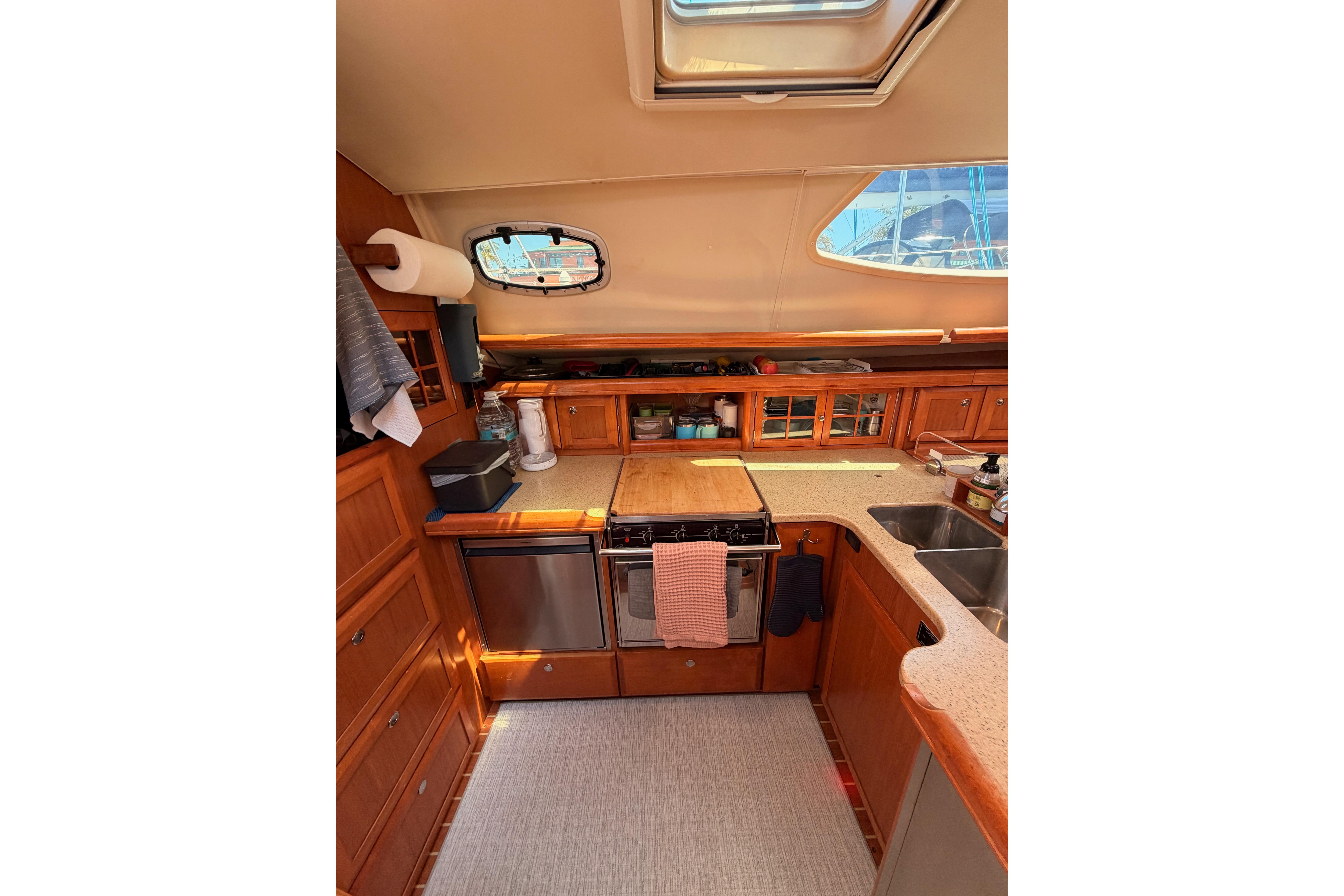 Interior of 2008 Hunter 45 Deck Salon yacht kitchen with wooden cabinetry and modern appliances.