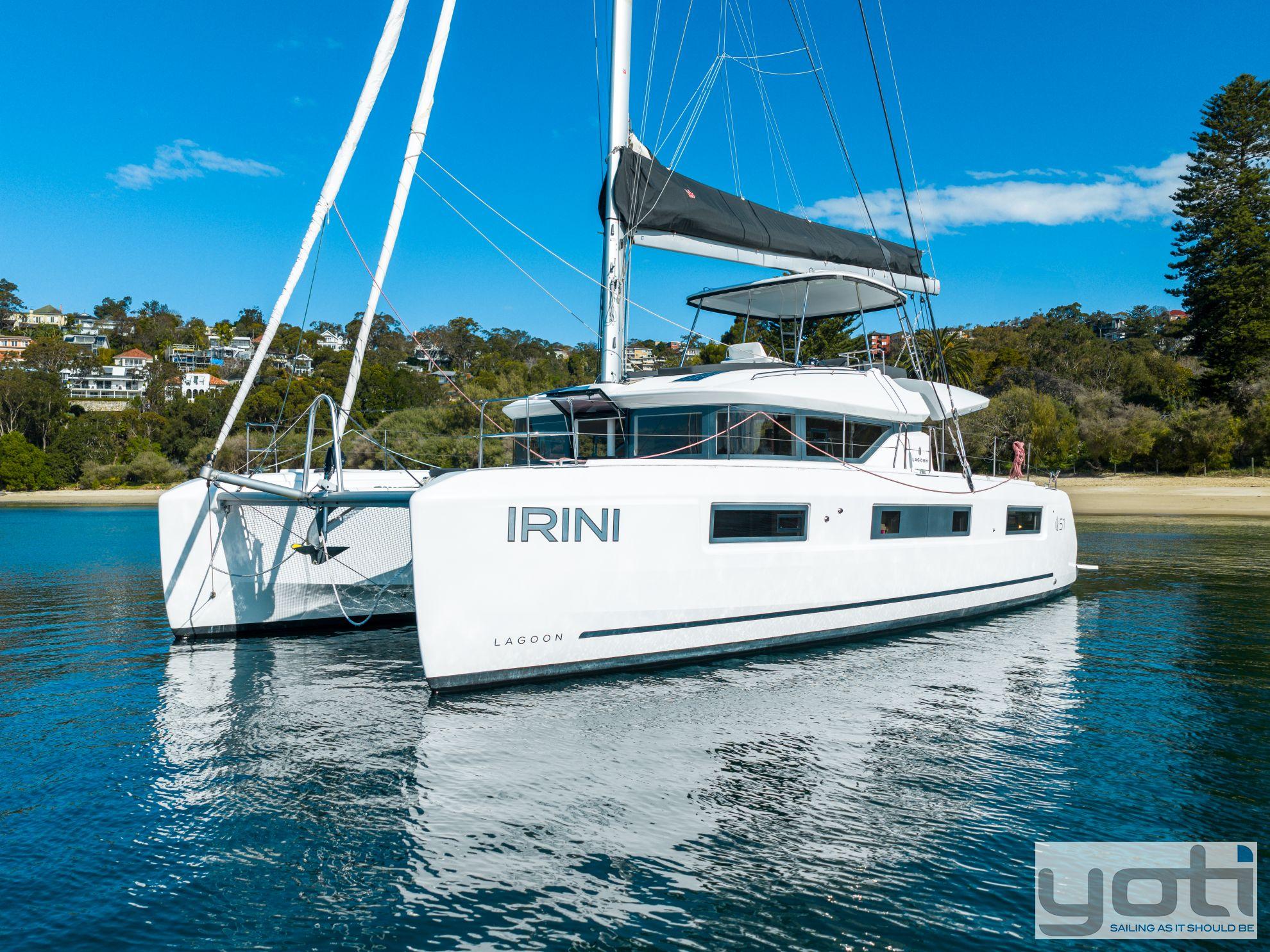 2023 Lagoon 51 catamaran "IRINI" sailing near a scenic shoreline.