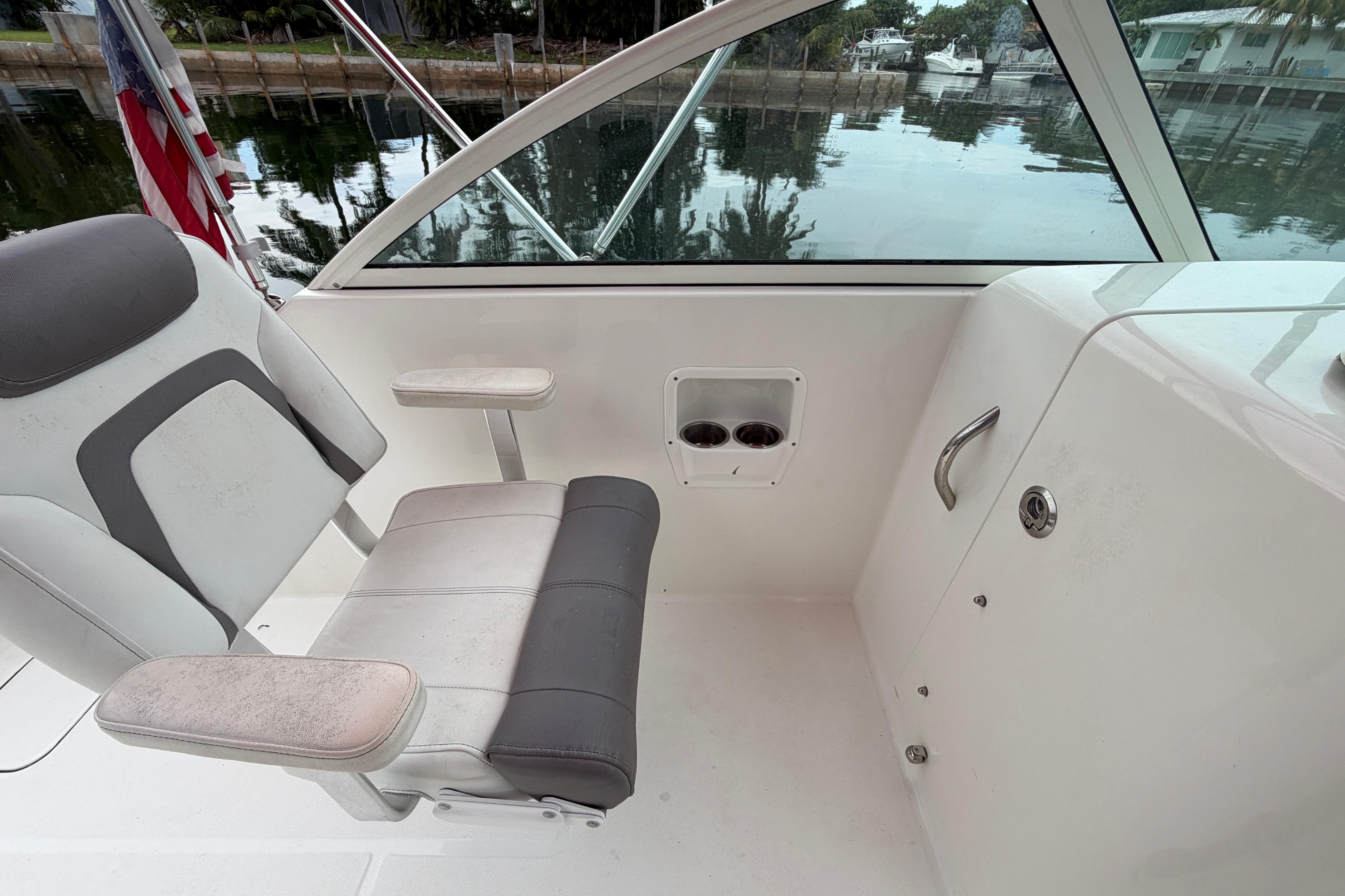 2019 World Cat 230 DC boat interior with seat and cup holders by the water.
