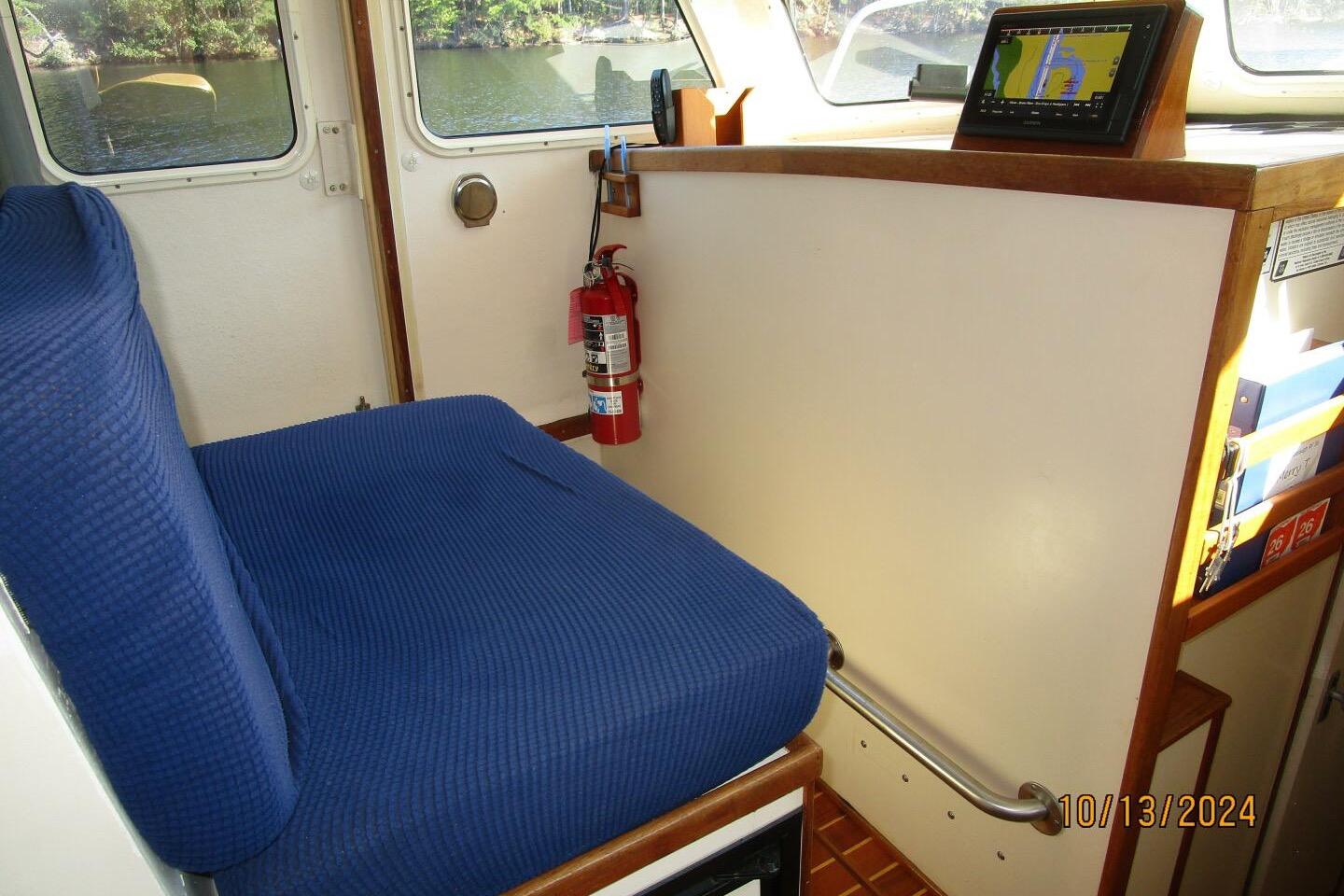 Interior of a 1997 Rosborough Trawler with blue seating and navigation equipment.