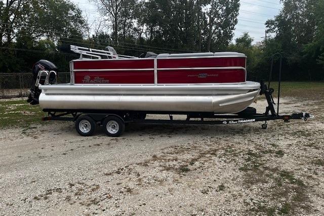 2026 Sun Tracker Party Barge 20 DLX pontoon boat on trailer, parked outdoors.