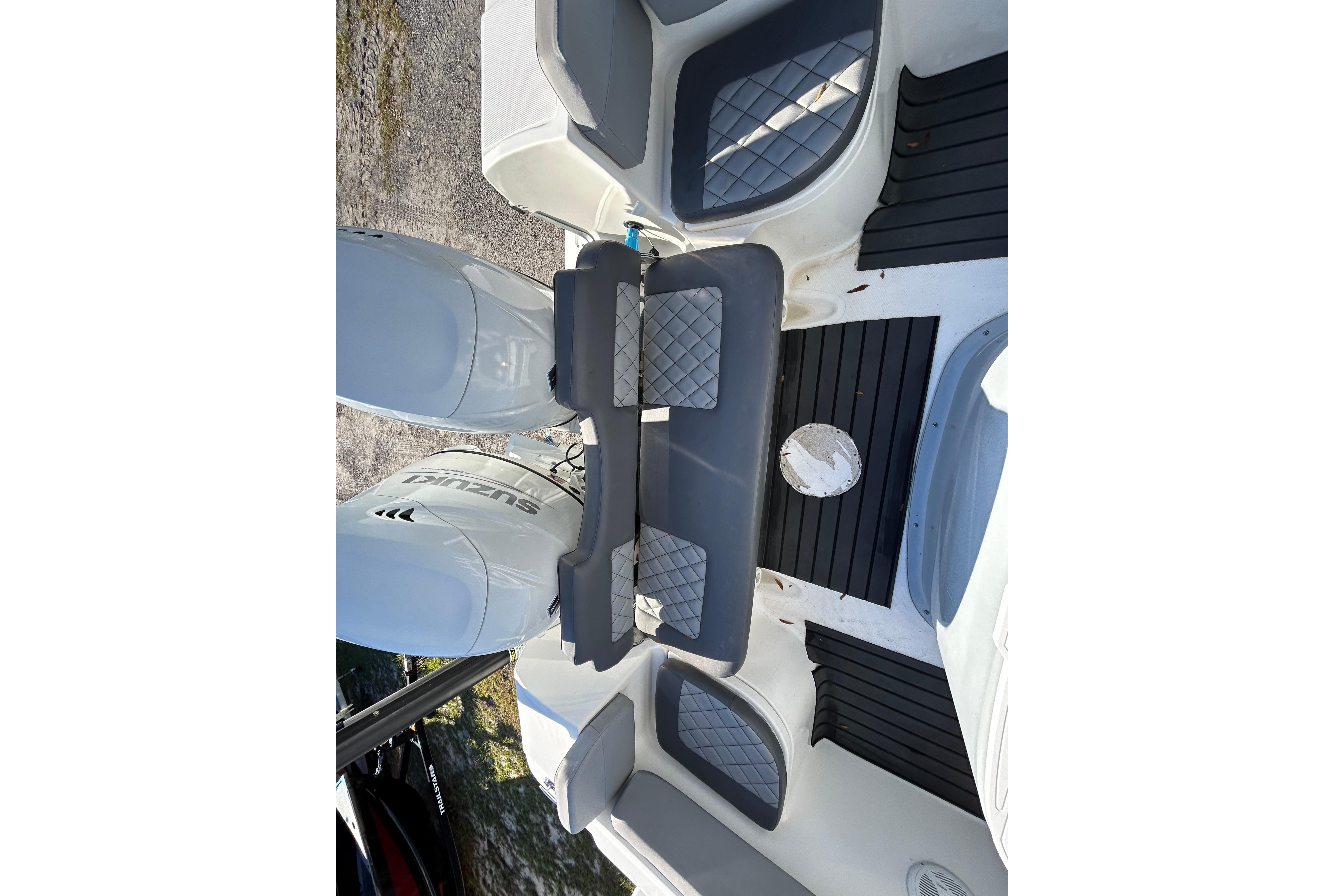 2022 Clearwater 2300 boat interior with dual Suzuki engines and cushioned seating.