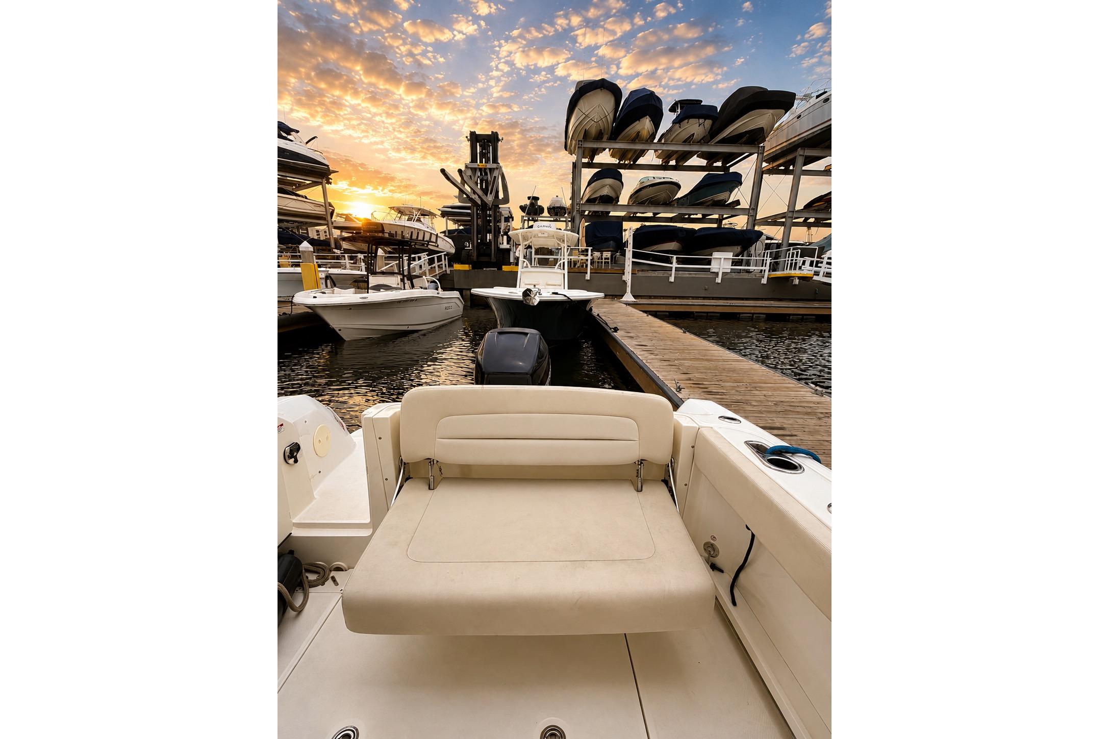 2017 Boston Whaler 230 Vantage at marina during sunset, showcasing docked boats and vibrant sky.