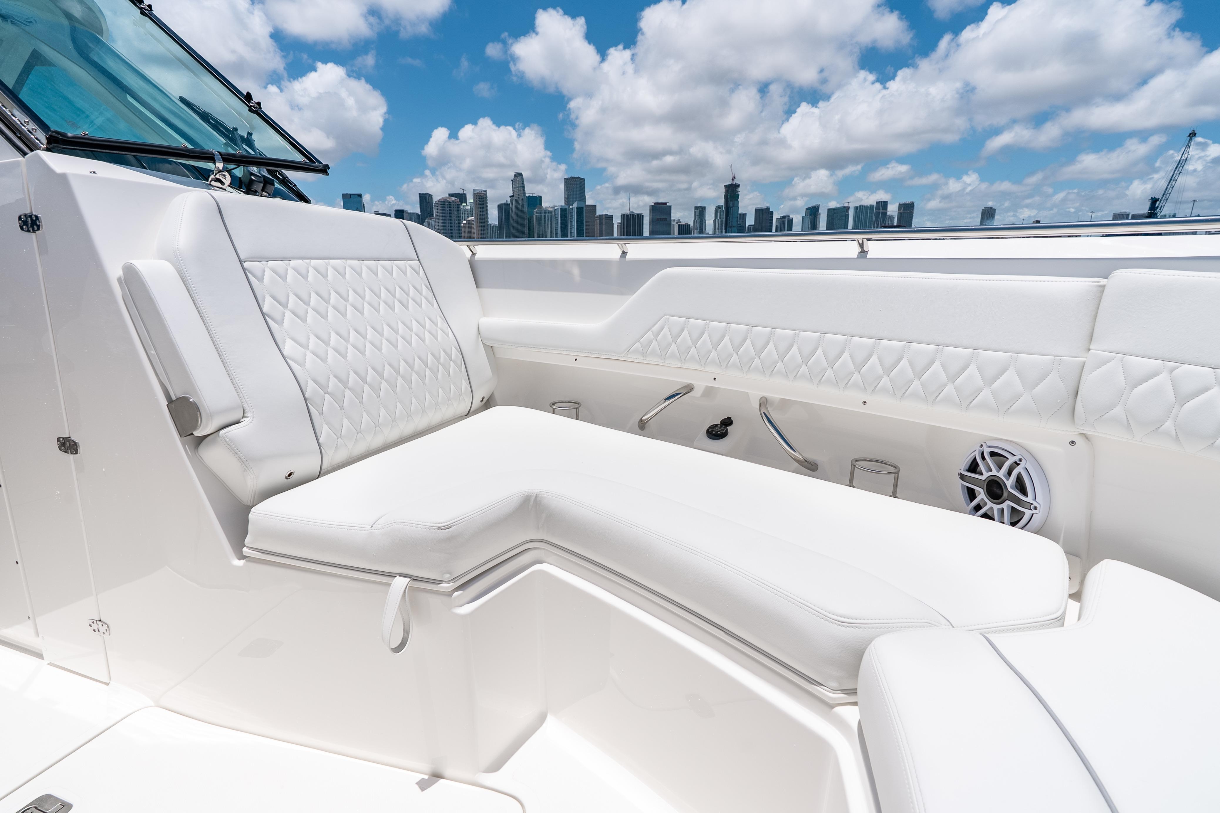 Luxurious seating on 2026 Pursuit DC 326 Dual Console boat with city skyline backdrop.