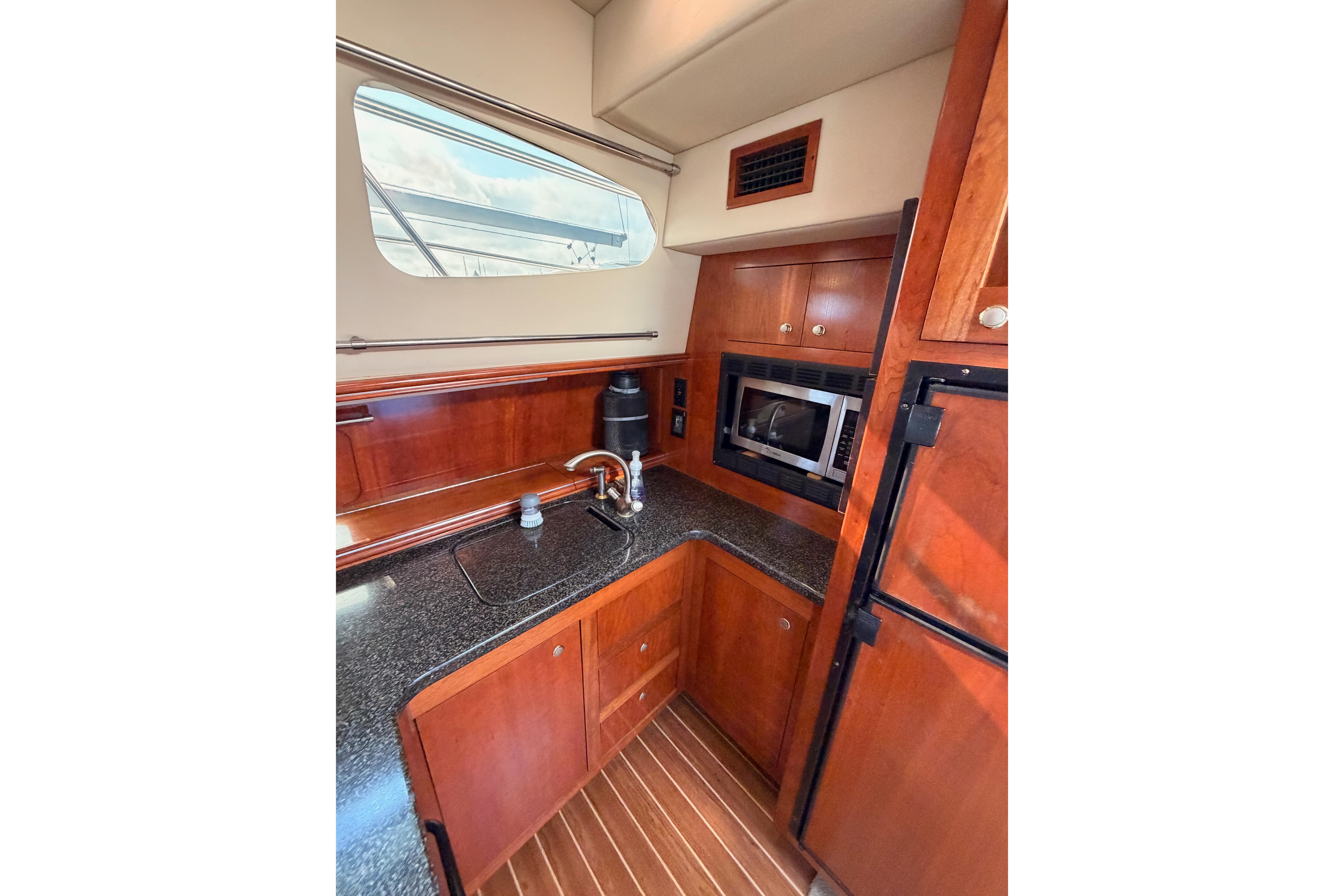 2005 Cruisers Yachts 405 Express Motoryacht kitchen with wood cabinetry and modern appliances.