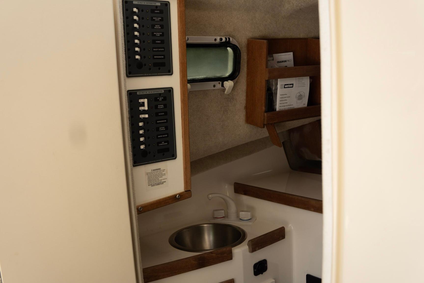 Interior of 2006 Atlas Boat Works Acadia 25, featuring control panels and compact sink area.