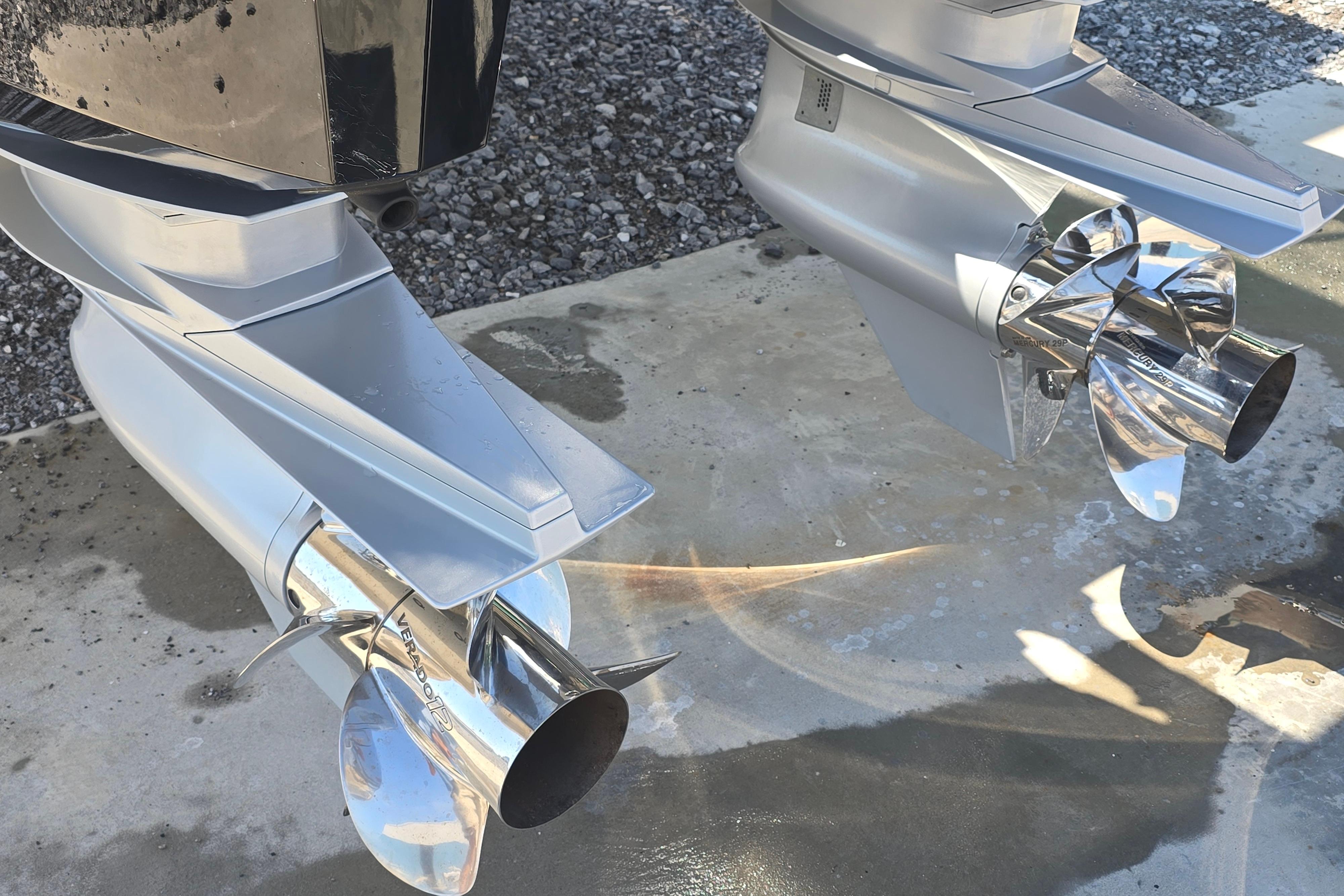 2025 Formula 380 Super Sport Crossover OB outboard motors with shiny propellers on concrete surface.