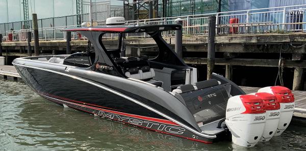 2017 Mystic Powerboats M4200 docked, featuring triple outboard engines.