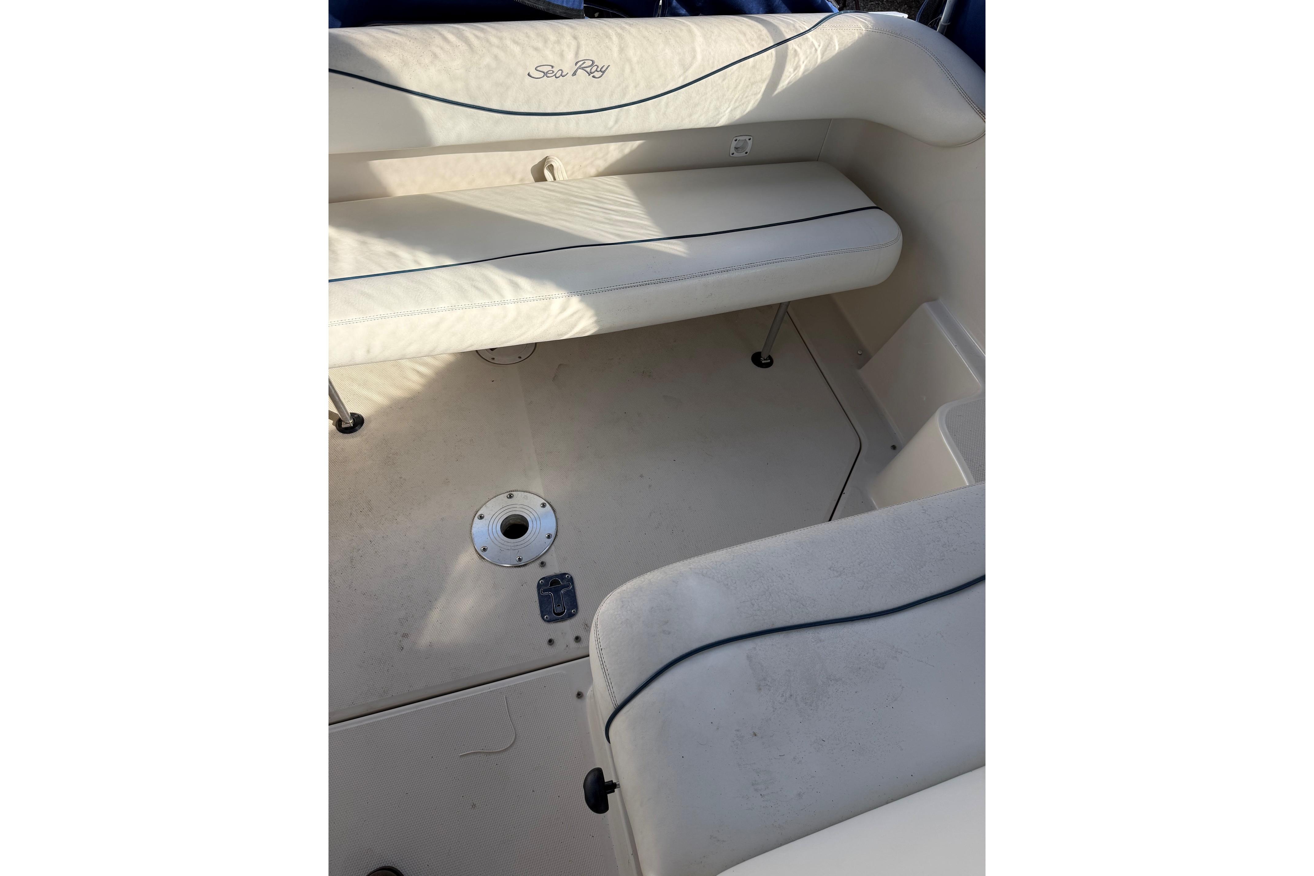 Interior seating of 2000 Sea Ray 240 Sundancer boat, featuring white upholstery.