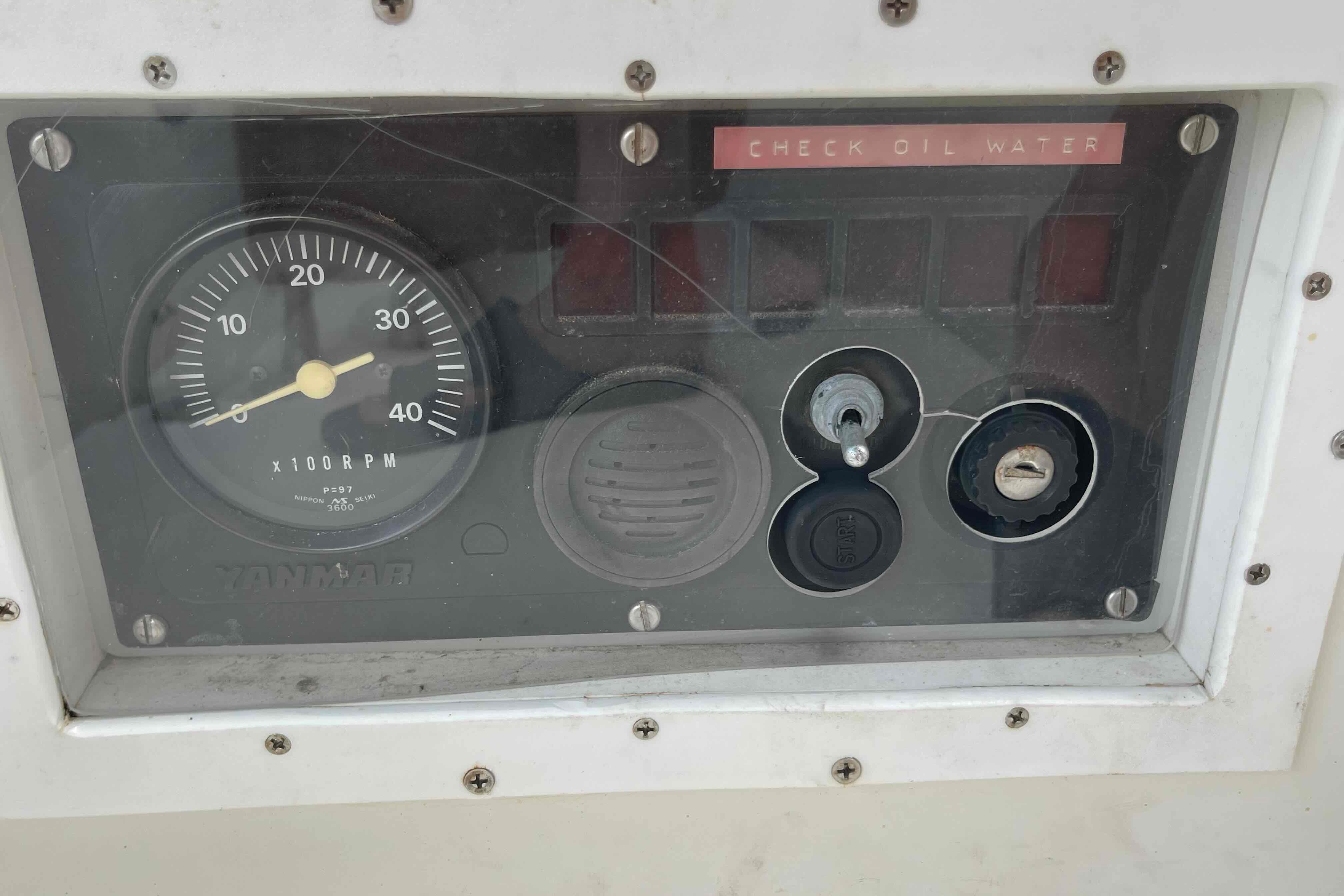 Control panel of a 1987 Pacific Seacraft 34 sailboat with RPM gauge and ignition.