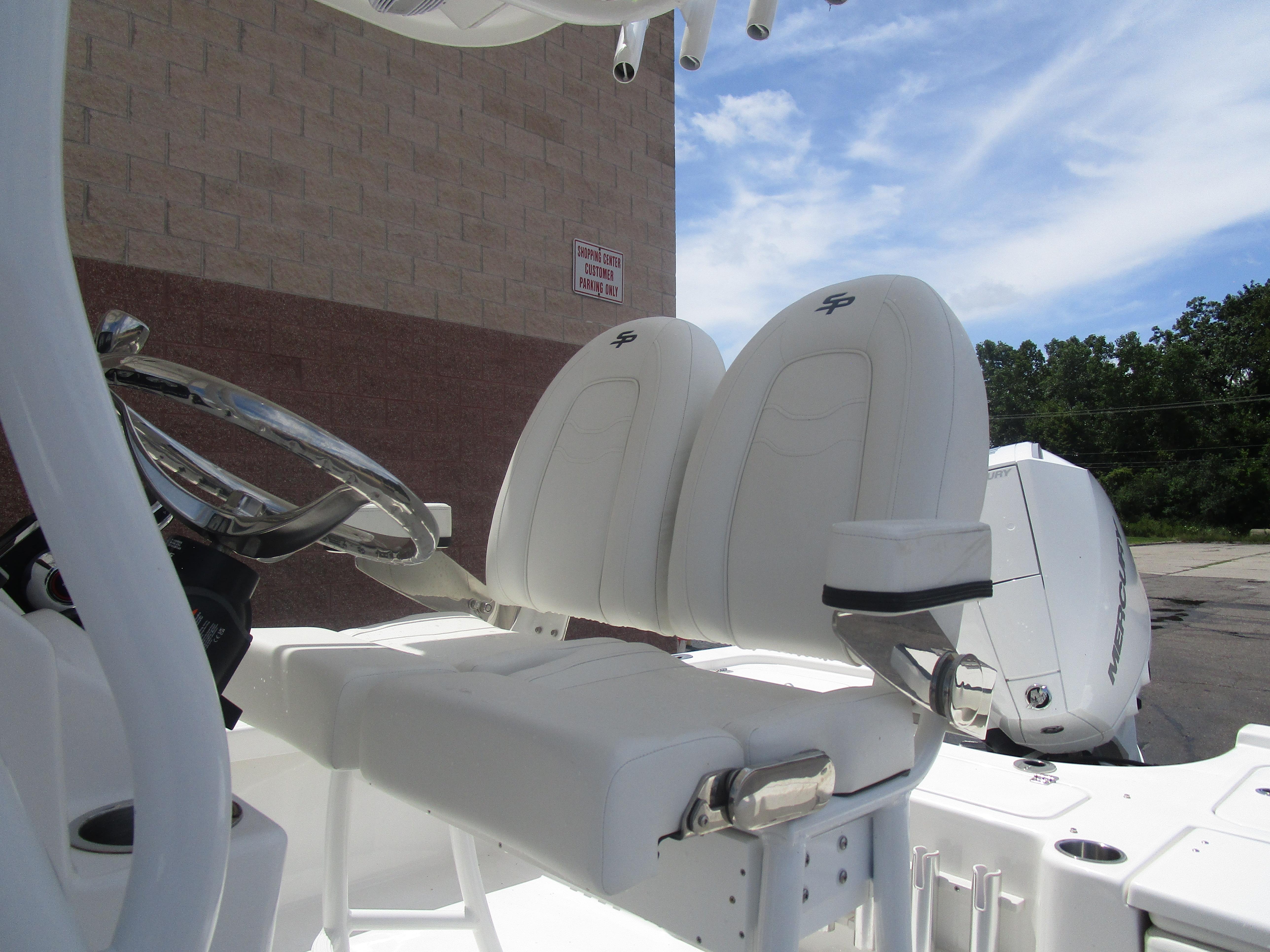 2025 Sea Pro 230 DLX BAY boat with white seating and steering wheel, outdoors.