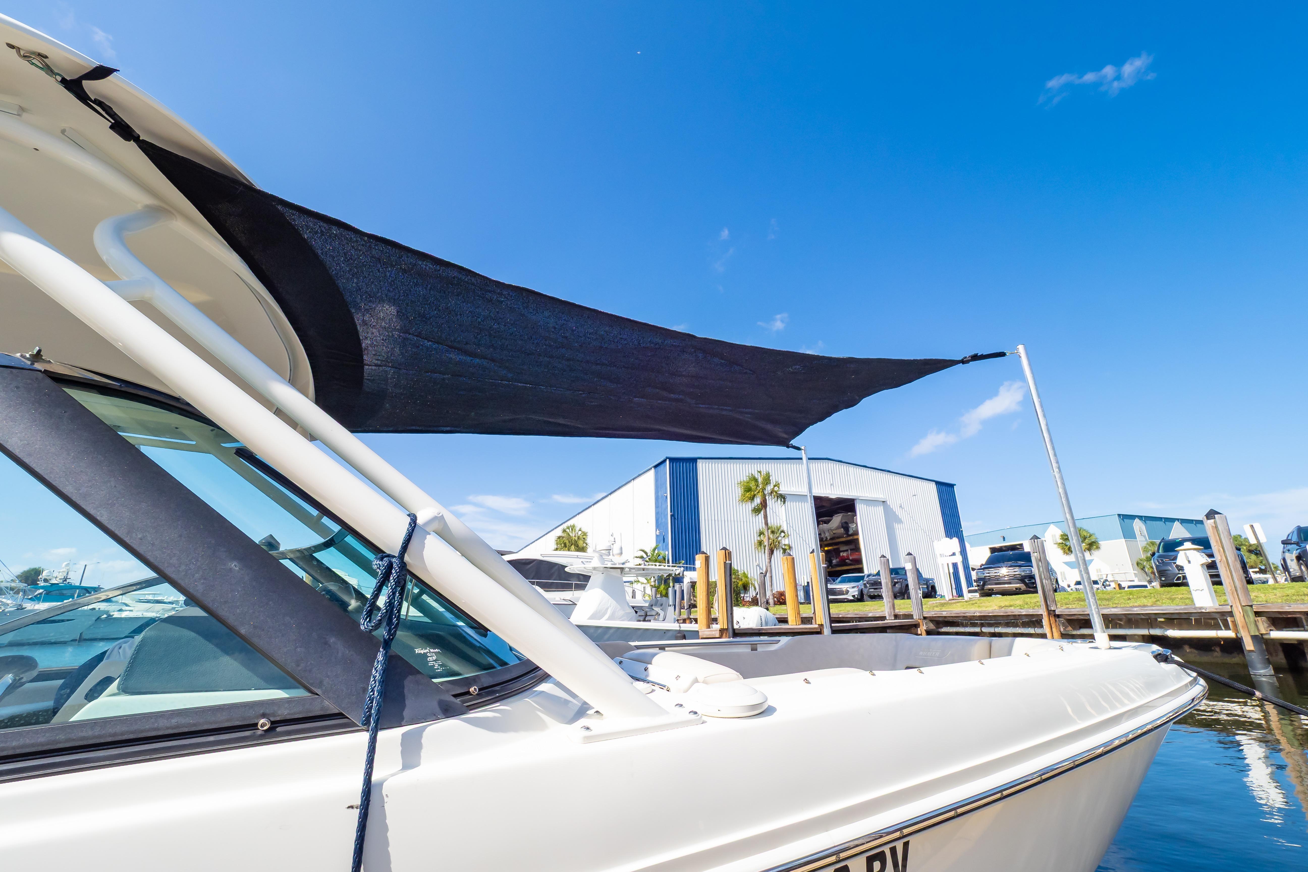 2019 Boston Whaler 270 Vantage boat docked under clear blue sky.
