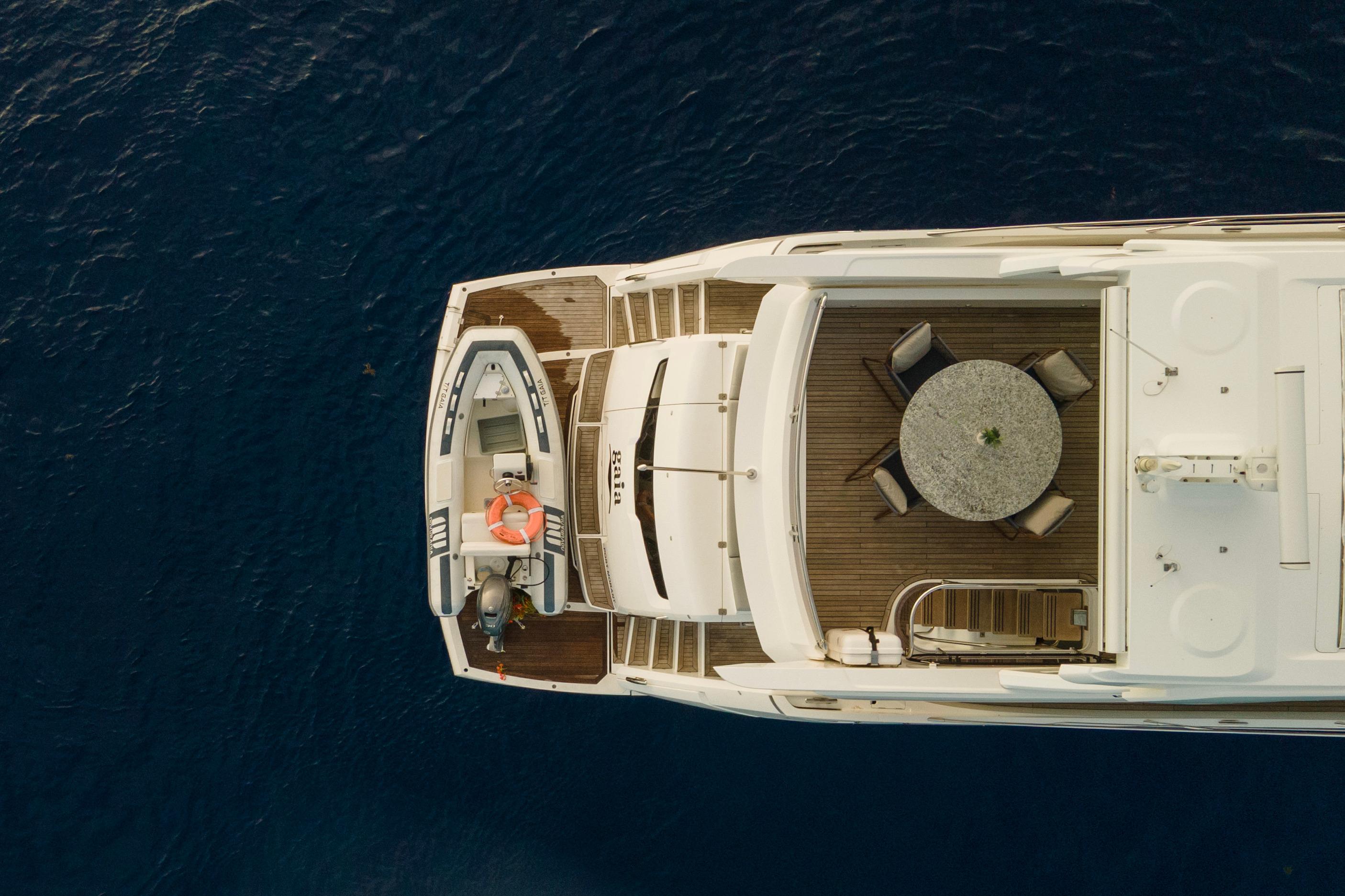 Aerial view of 2022 Sunseeker Manhattan 68 yacht with deck seating and tender.