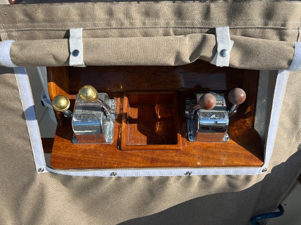 Close-up of control levers on a boat, surrounded by brown fabric.