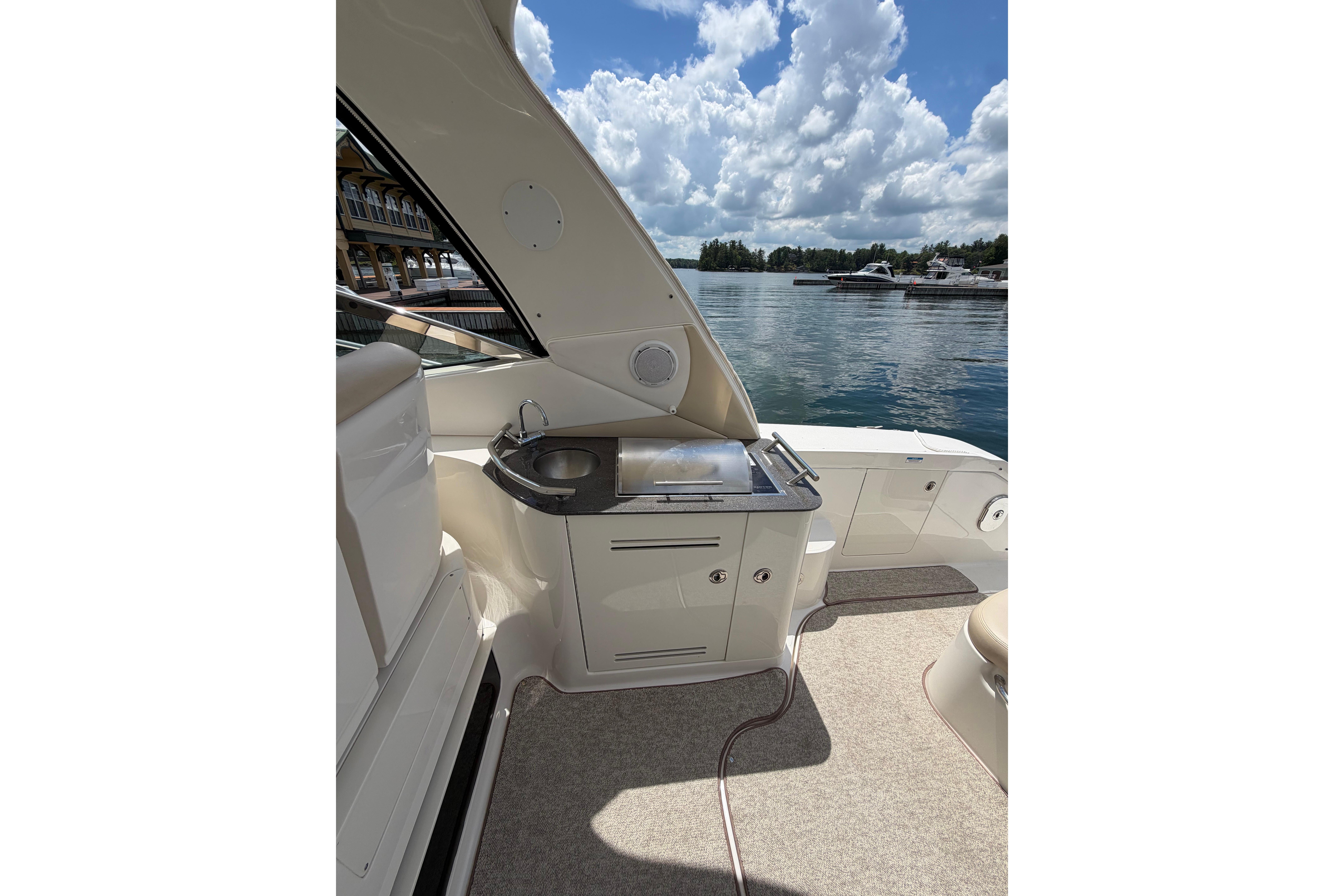 Luxurious 2012 Sea Ray Sundancer 370 yacht interior with kitchenette, overlooking serene waters.