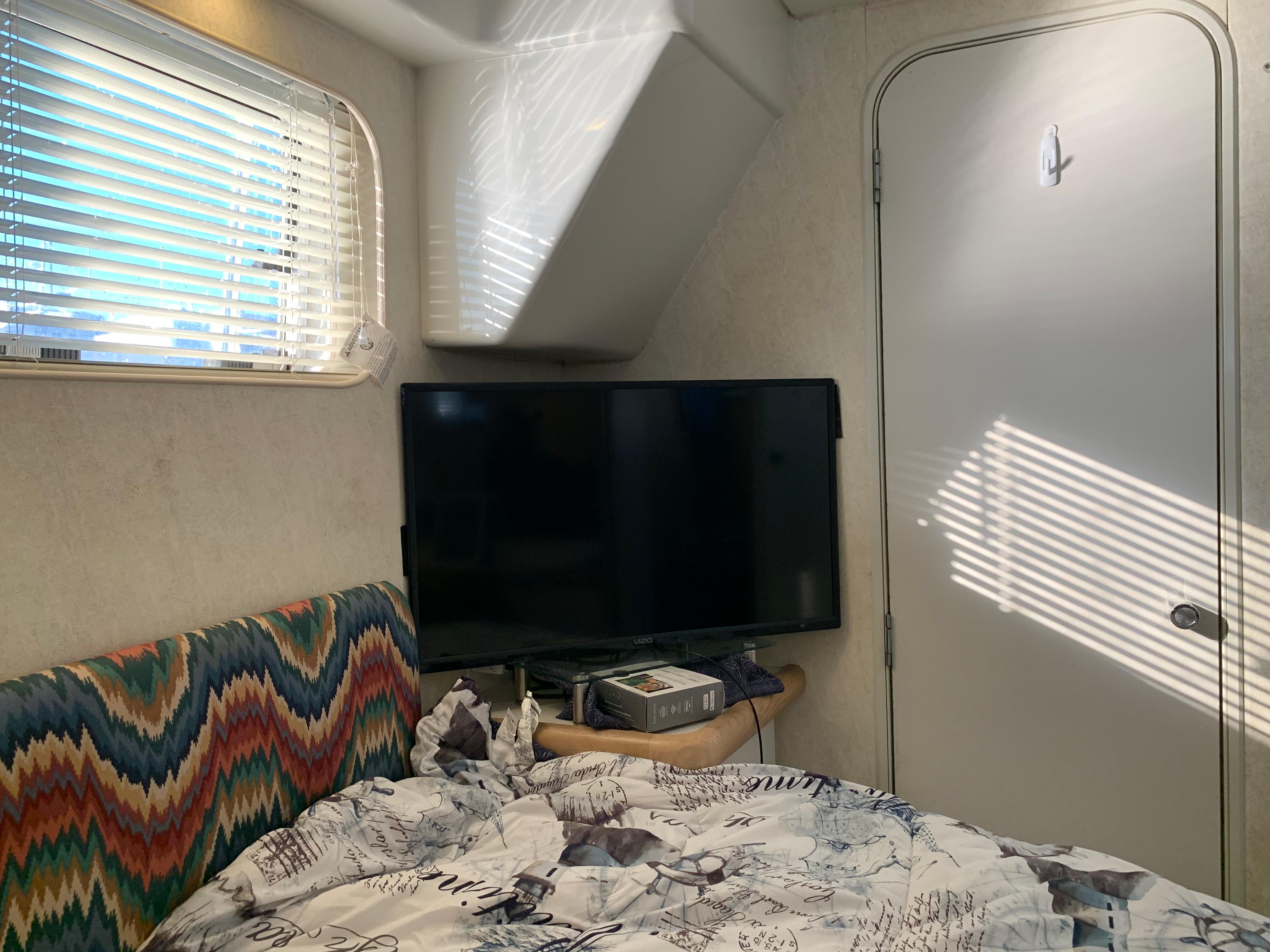 Interior of 1992 Silverton 34 Aft Cabin Motor Yacht with TV and patterned bedding.