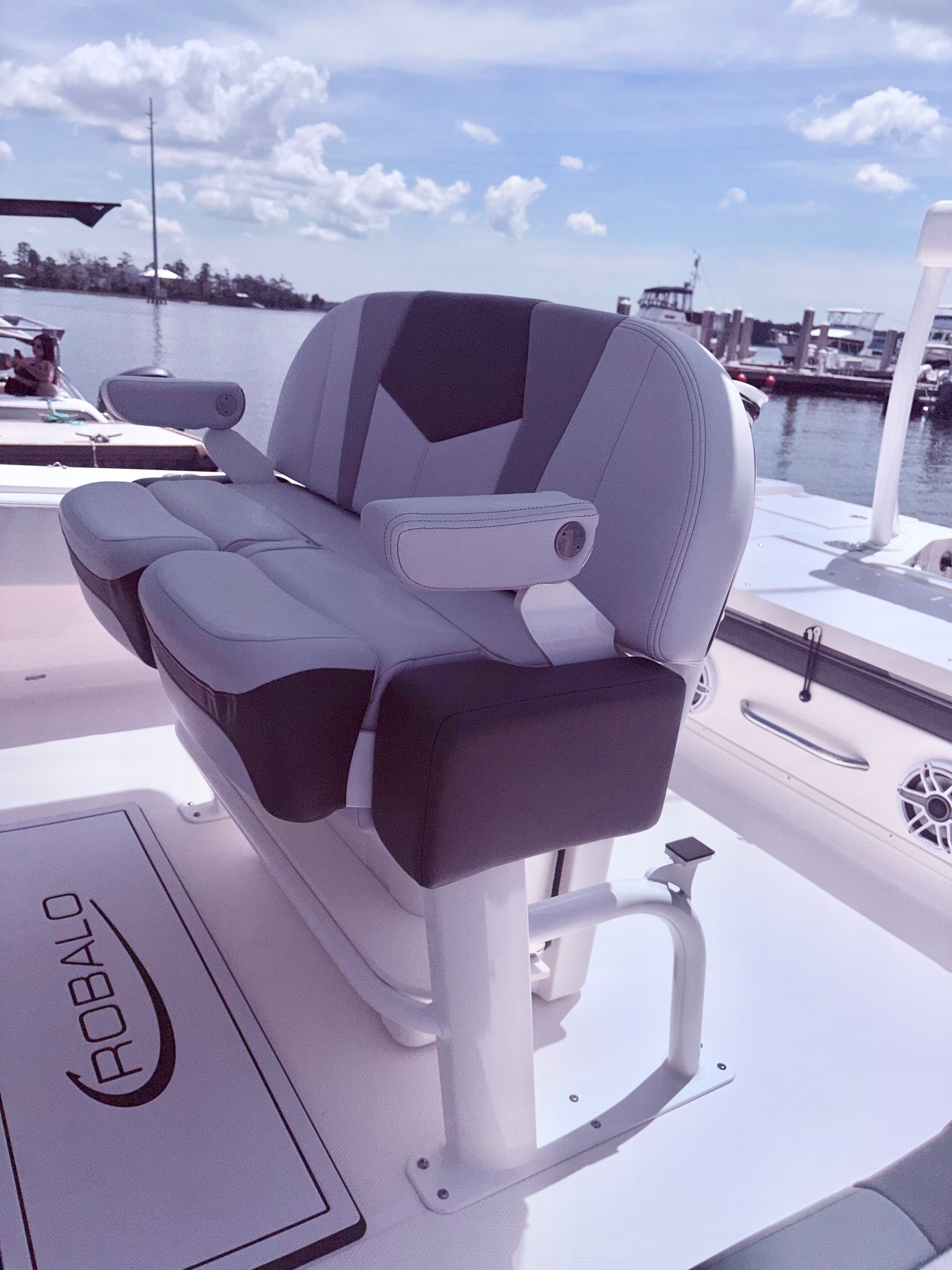 Robalo 266 Cayman 2025 boat seat on deck by the water.