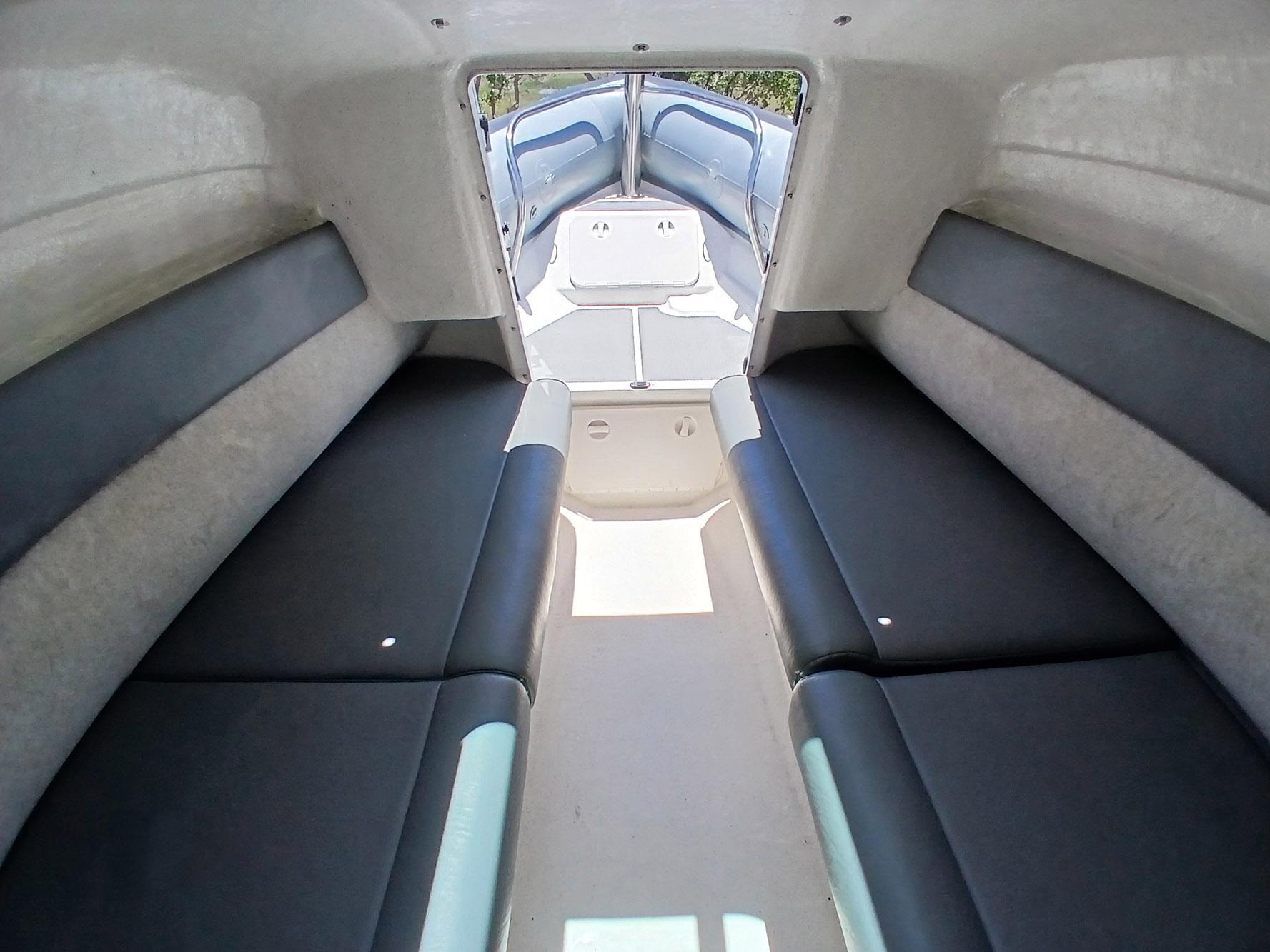 Interior of 2002 Protector 28 Targa boat, featuring cushioned seating and spacious cabin layout.