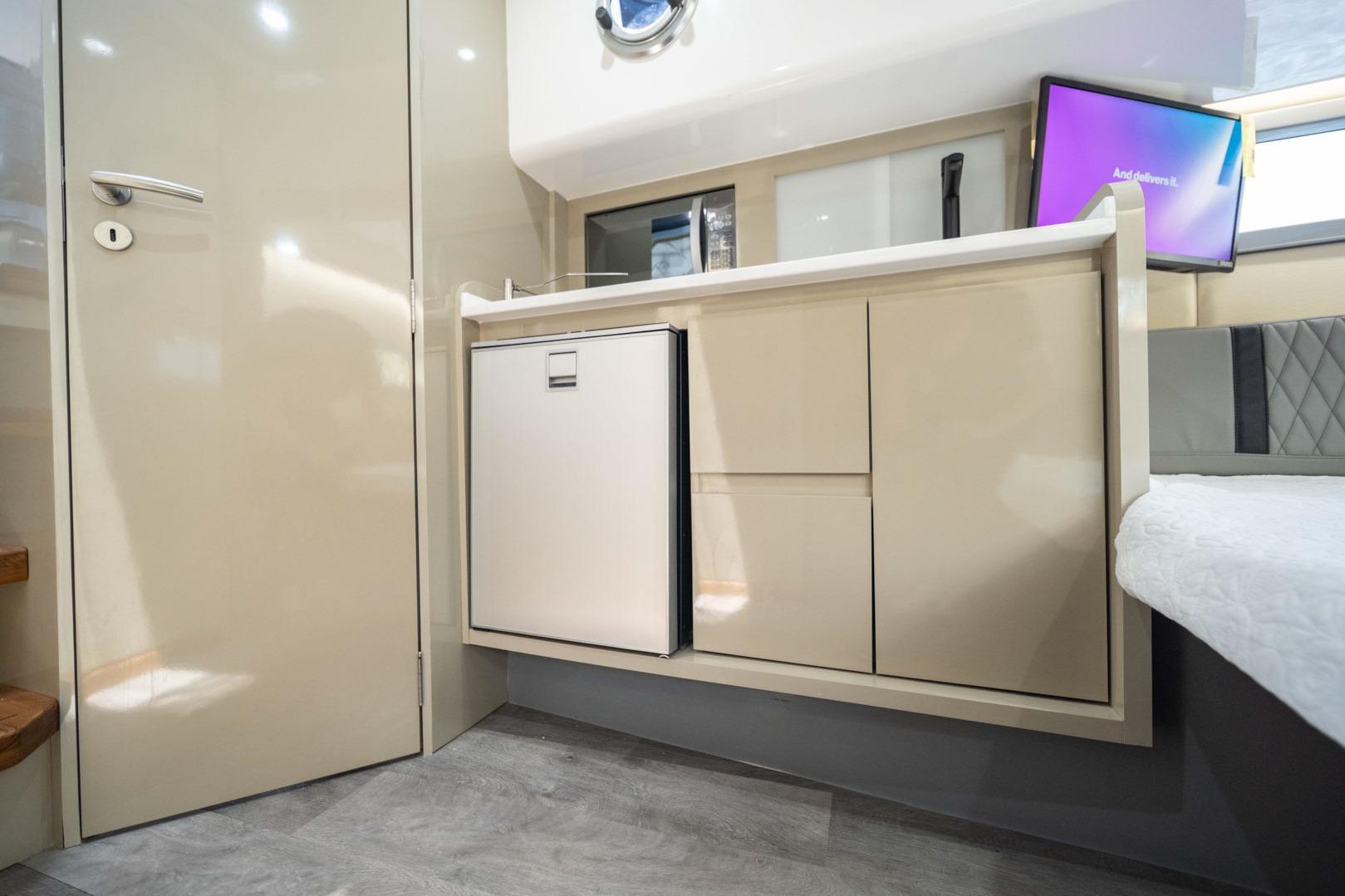 Modern interior of 2026 Hanover 387 with sleek cabinetry and compact fridge.