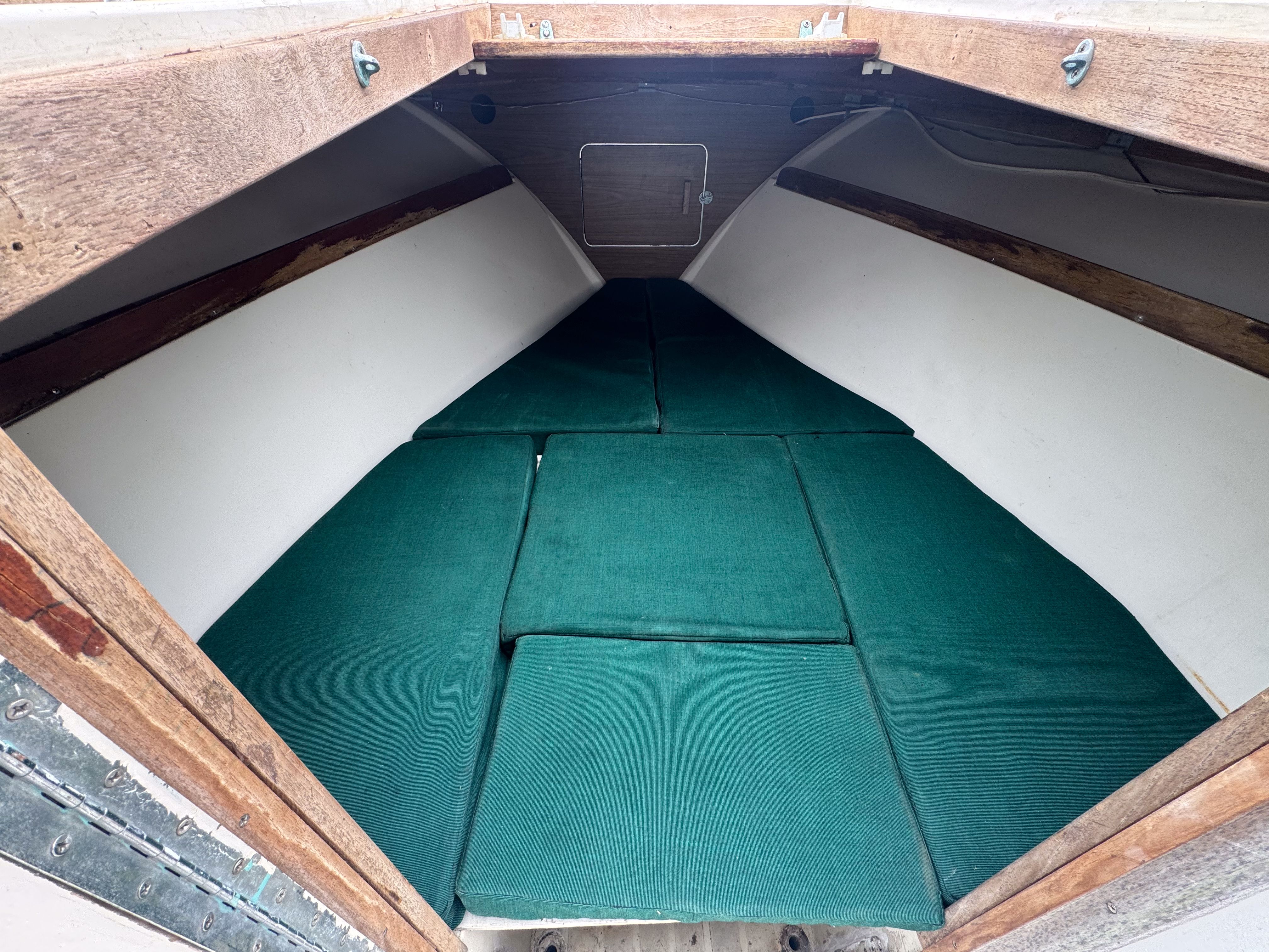 Interior of a 1973 SeaCraft TSUNAMI boat with green cushions.