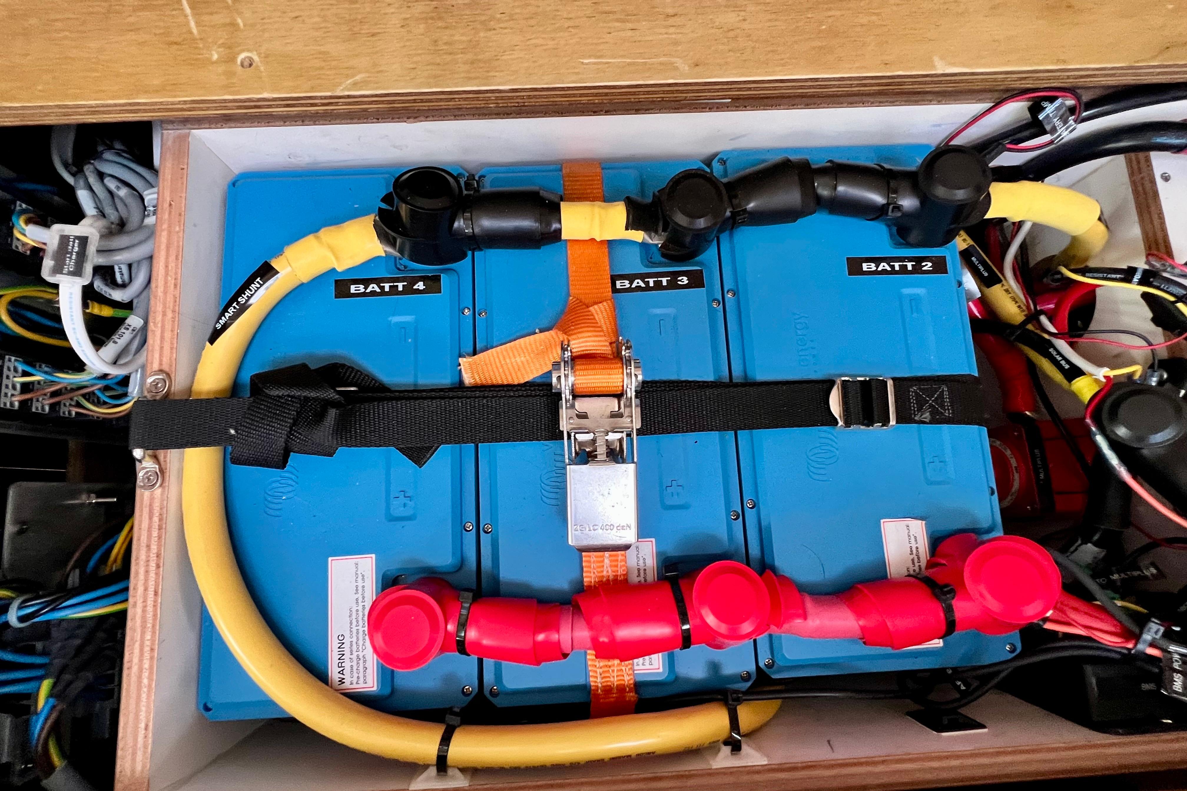 Battery compartment of a 2016 Hanse 455 yacht, featuring organized wiring and labeled batteries.
