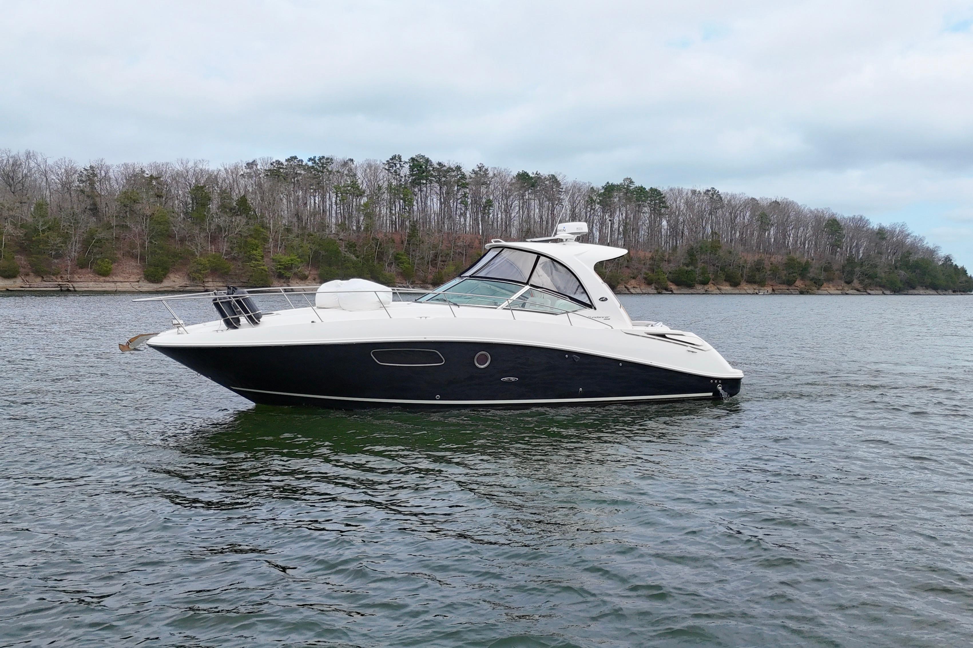 2009 Sea Ray Sundancer 350 yacht on a calm lake with wooded shoreline.
