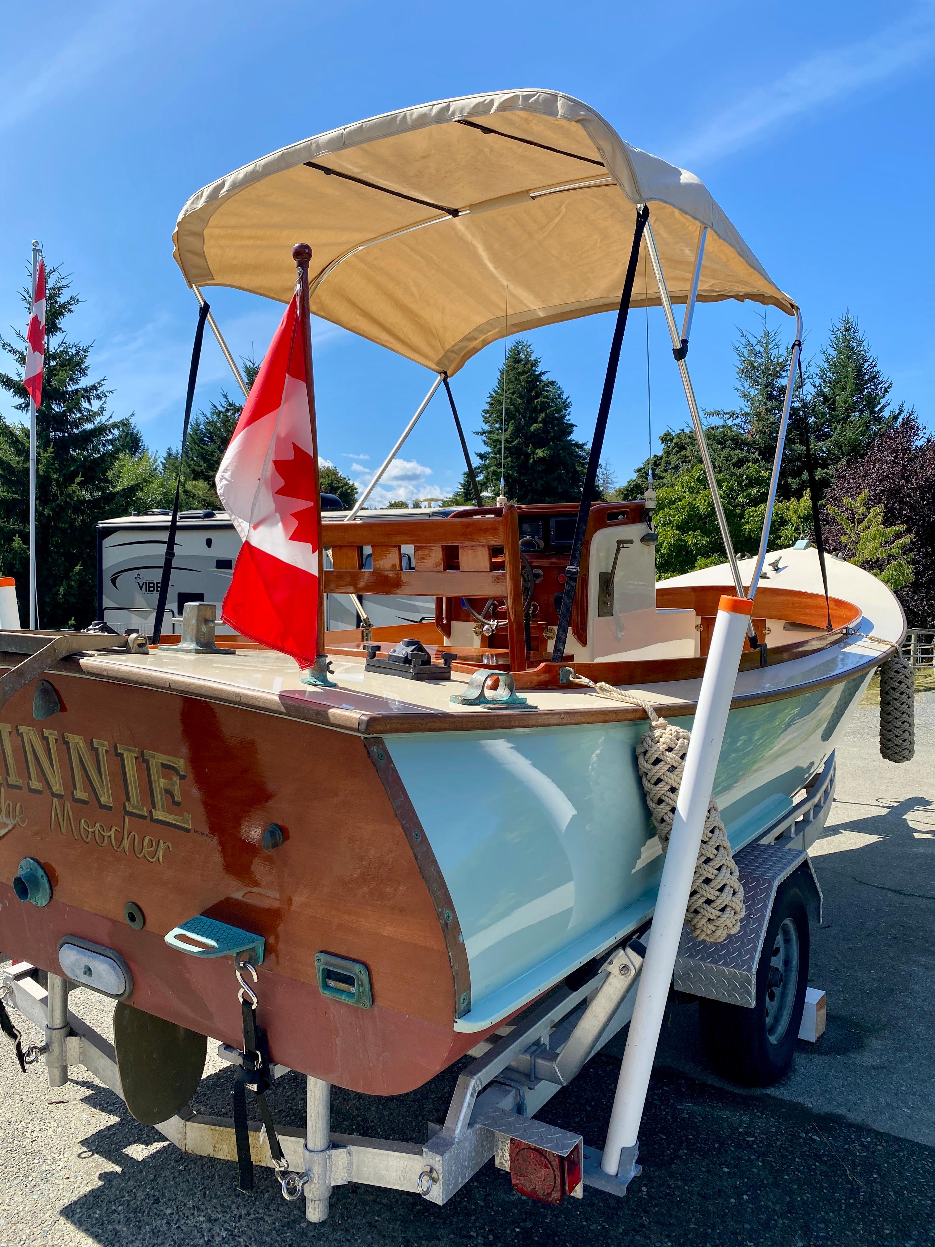 2014 Stimson Ocean Pointer Launch boat with canopy and Canadian flag on trailer.