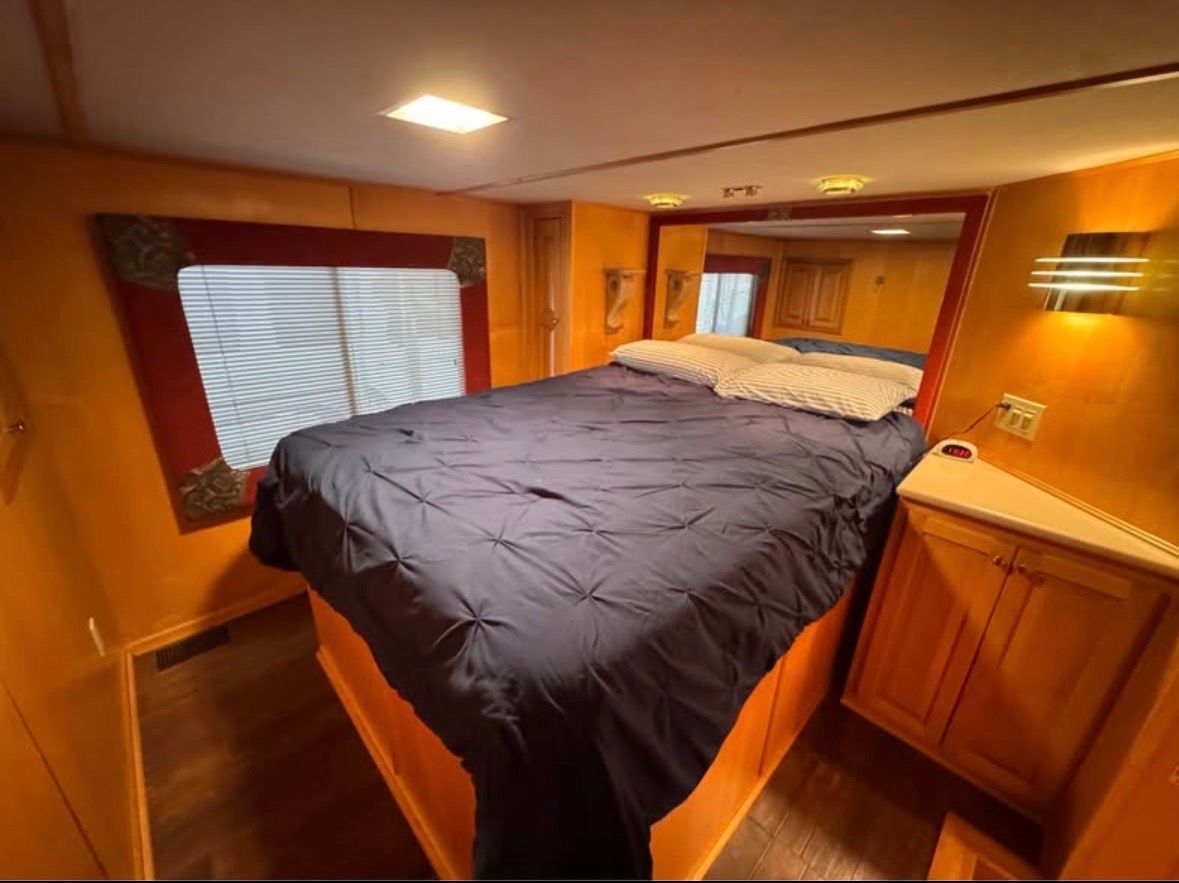 Interior of a 1998 Stardust Cruisers houseboat with cozy bedroom.