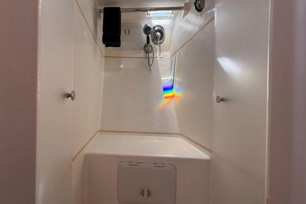 Compact shower area in 2011 Reliance 44 boat with rainbow light reflection.