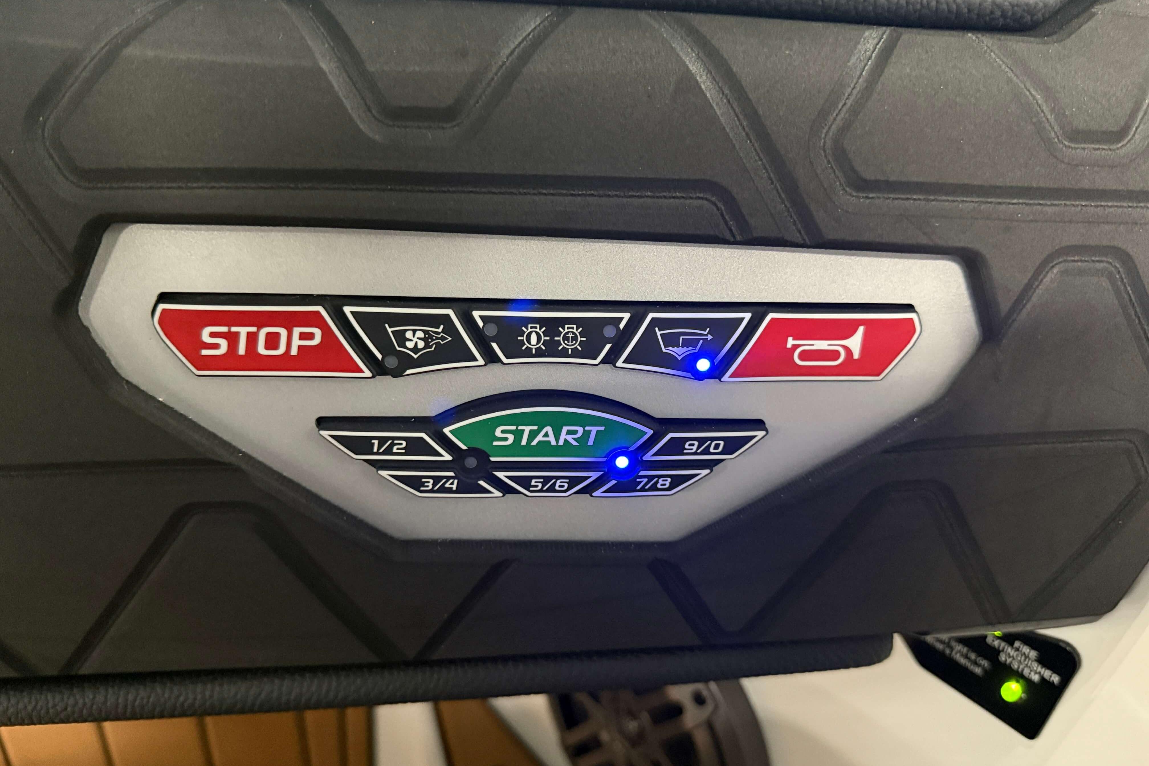 Control panel of 2026 Nautique Super Air Nautique GS22 with start and stop buttons.