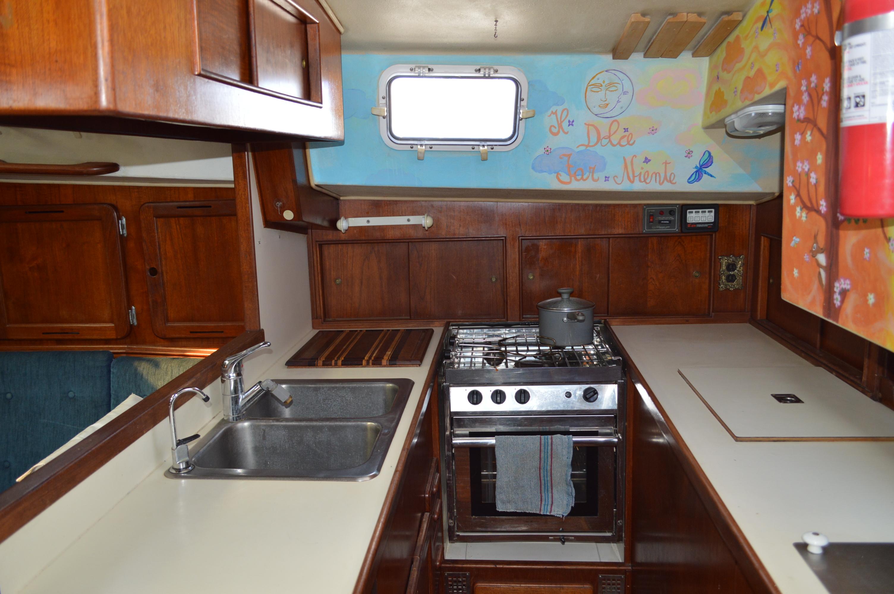 1979 Morgan 461 yacht kitchen with stove, sink, and wooden cabinetry.