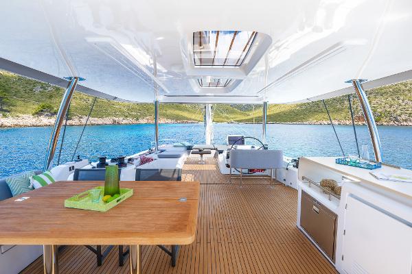 Luxurious Lagoon 60 yacht interior, 2025 model, featuring spacious deck and scenic ocean view.
