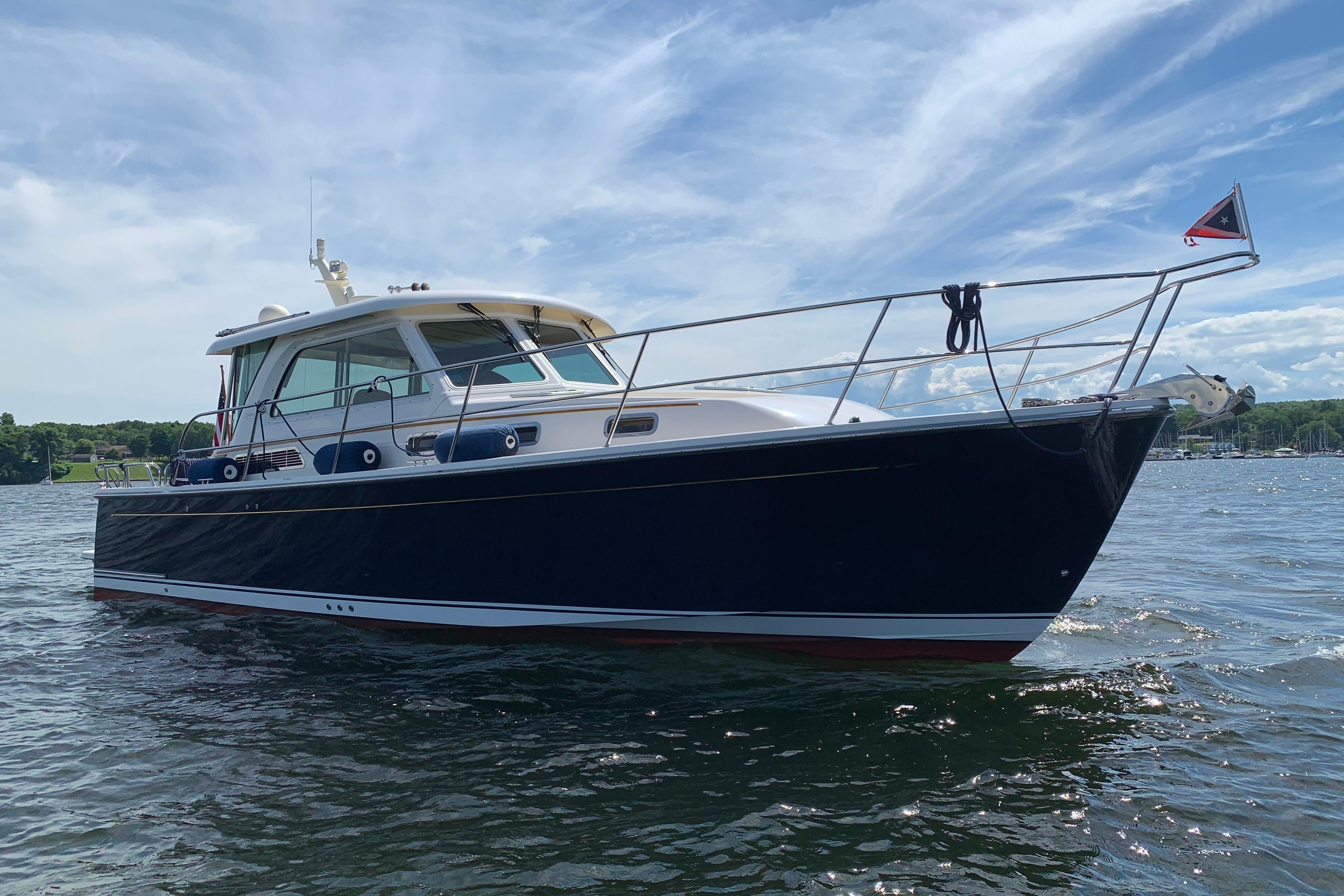 2015 Sabre 38 Salon Express yacht on calm water under a blue sky.