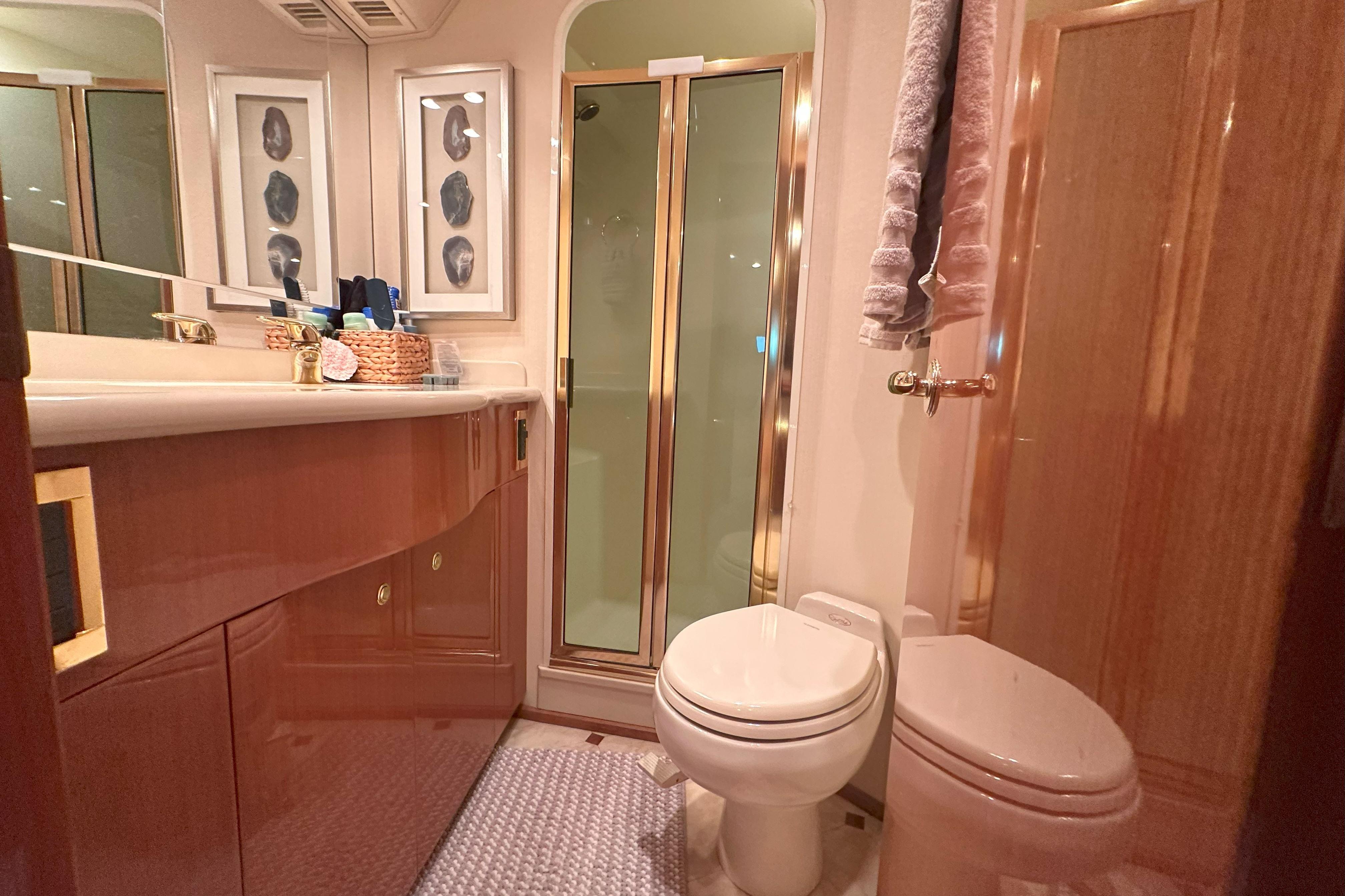 Luxurious bathroom in 2003 Viking 48 Convertible yacht with shower, toilet, and vanity.