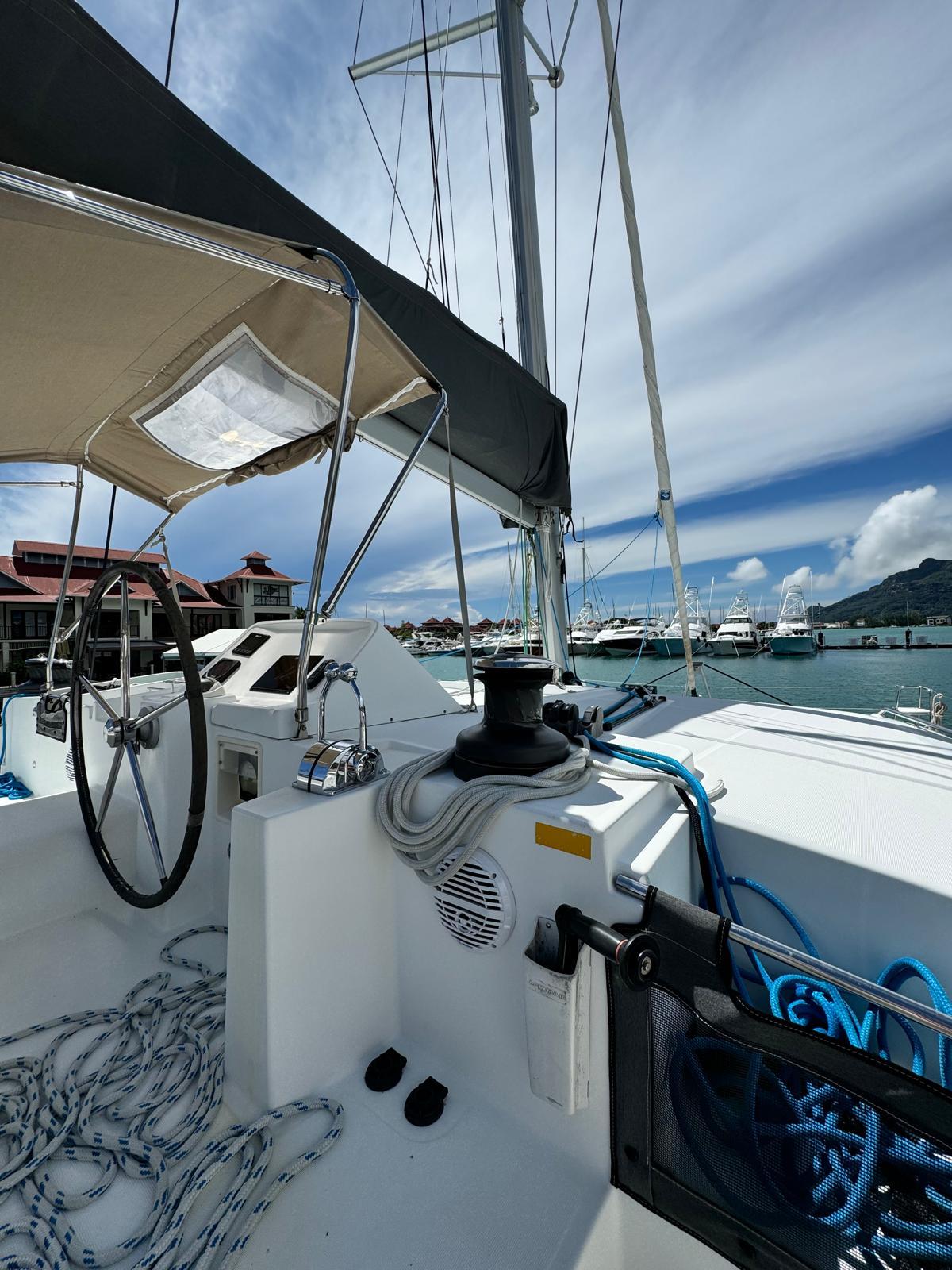 2015 Lagoon 450 F catamaran docked at marina, clear sky, nautical ropes visible.
