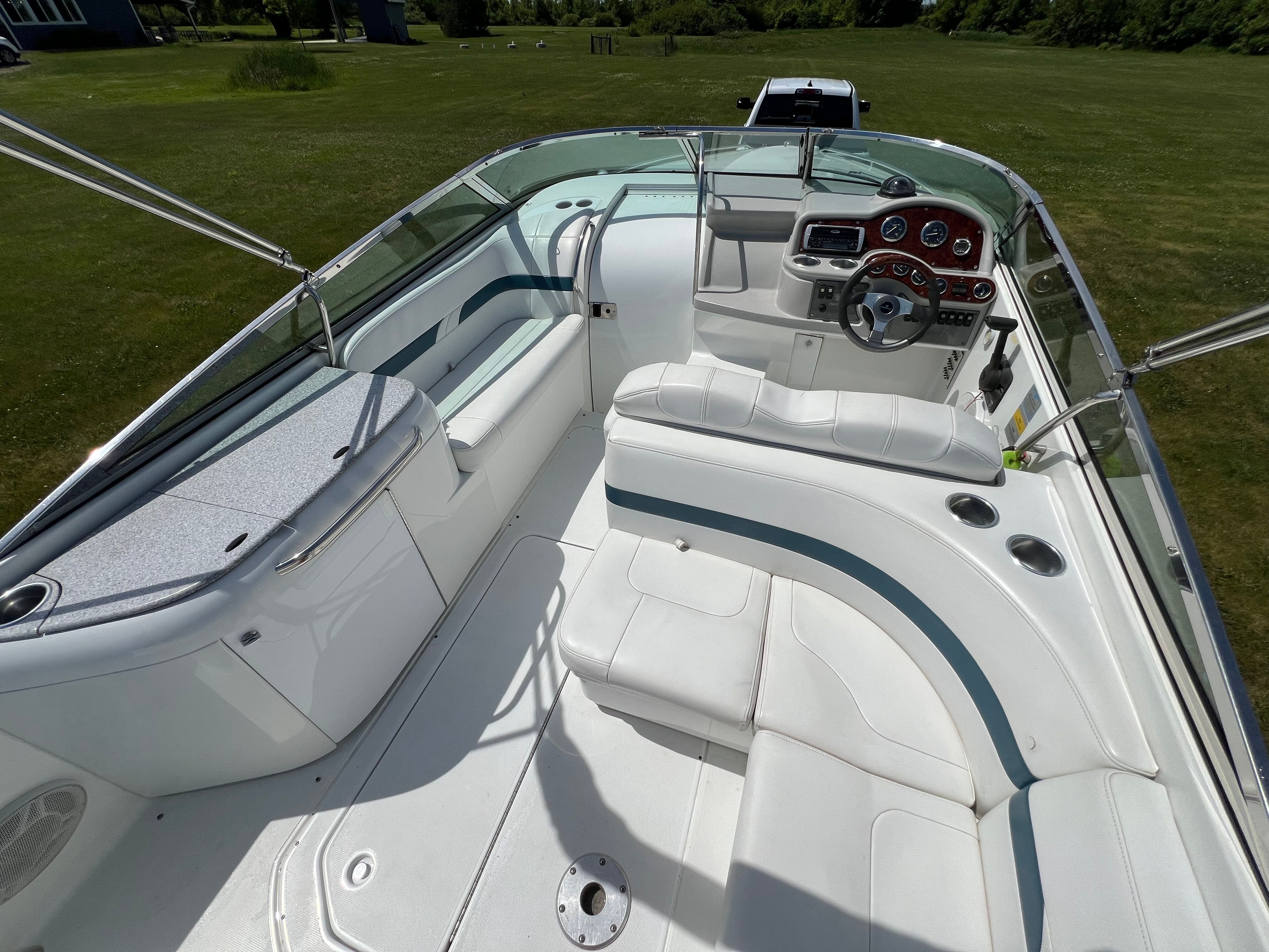 The image shows the cockpit of a 2005 Formula 260 Sun Sport boat with white upholstery and a sleek dashboard.