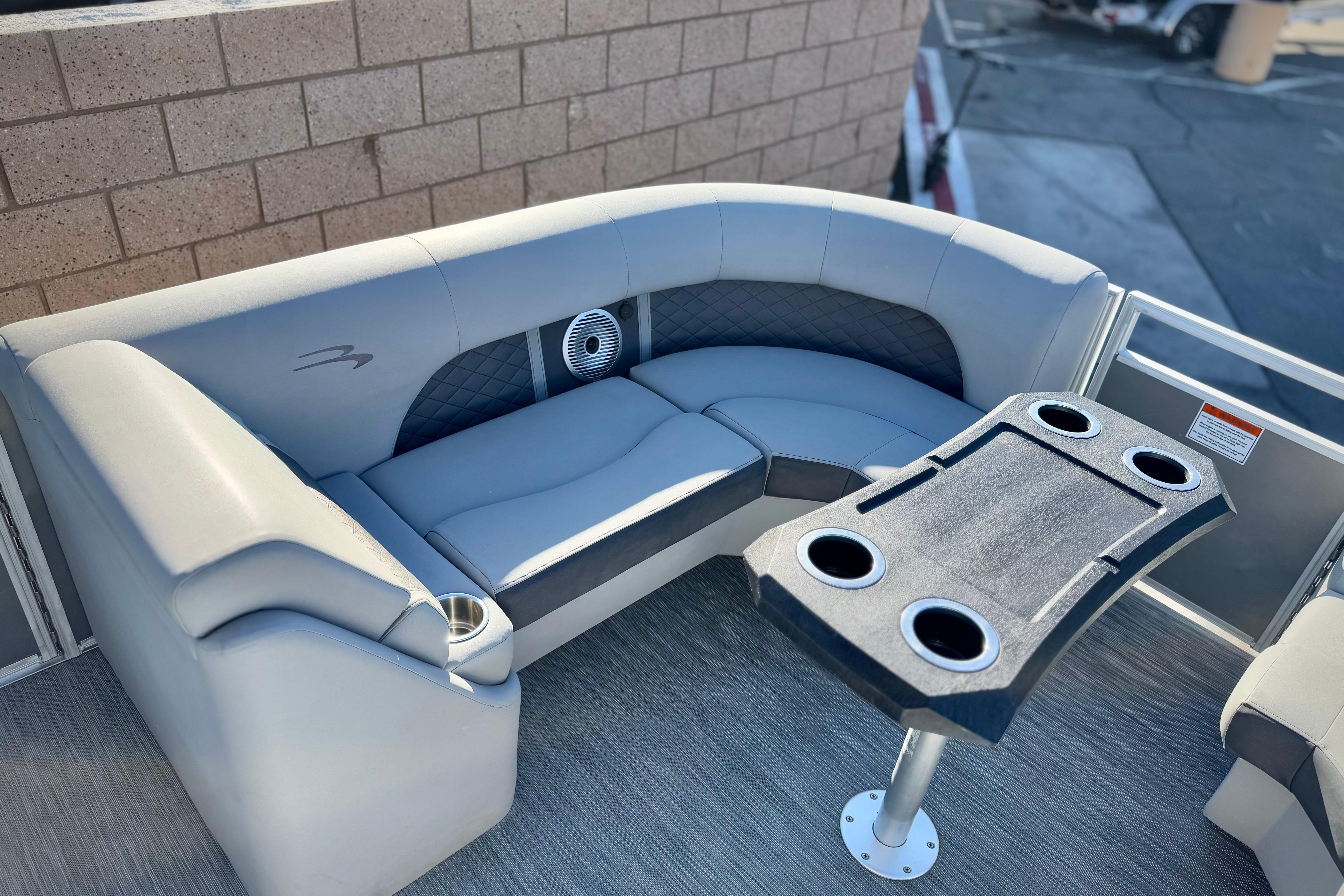 2021 Bennington 23LSR boat interior with gray seating and cupholder table.