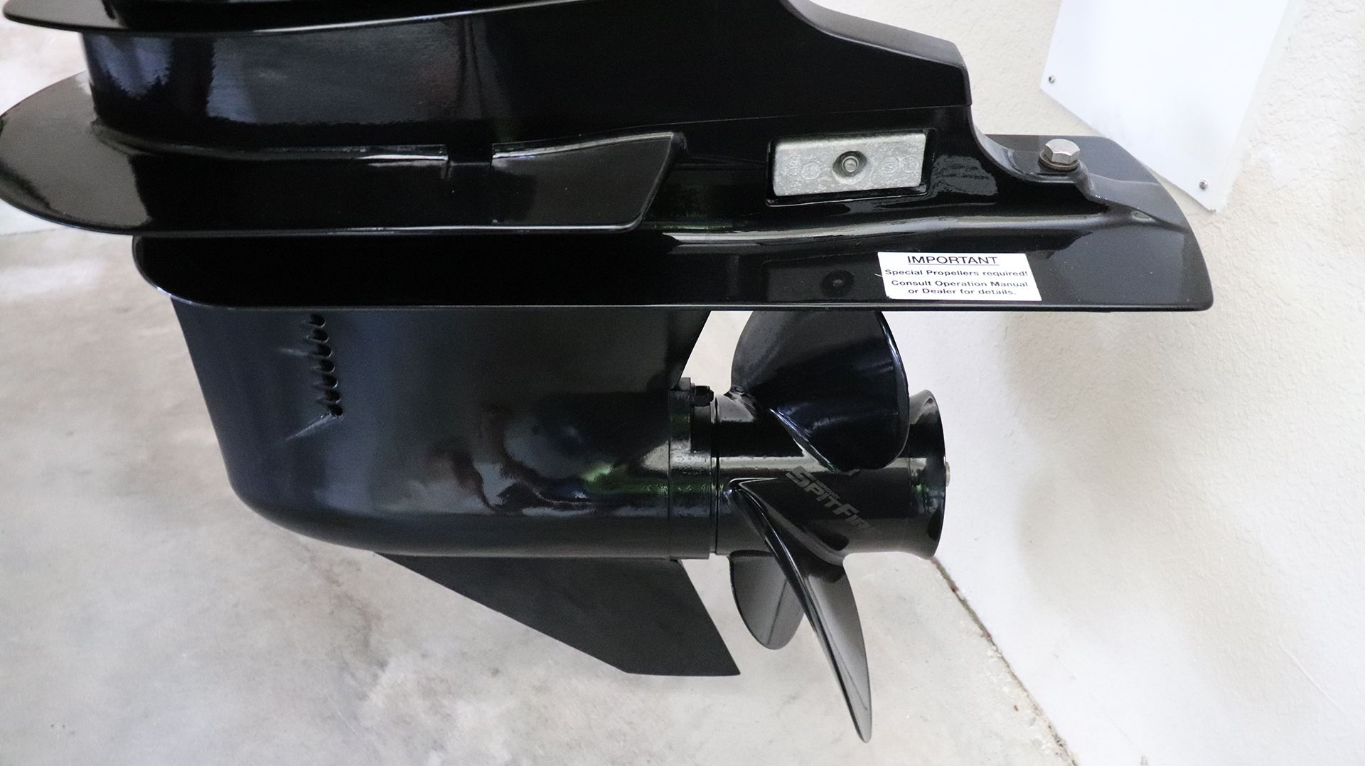 Close-up of a black boat propeller and drive assembly.