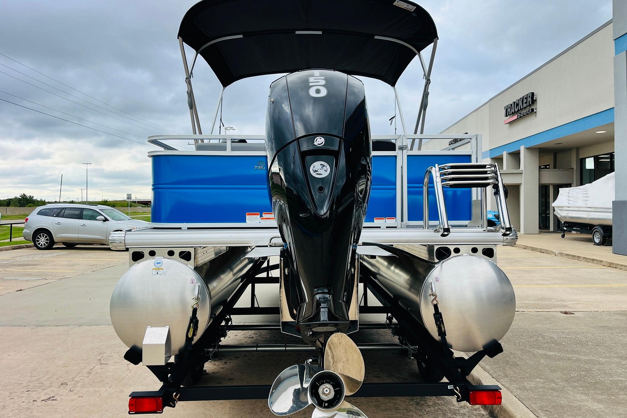 2026 Sun Tracker Party Barge 22 RF DLX pontoon boat with outboard motor, parked outdoors.