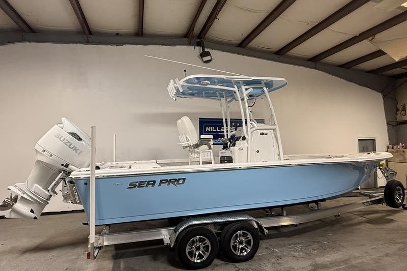 2026 Sea Pro 250 Bay boat in a garage, featuring a Suzuki outboard motor.