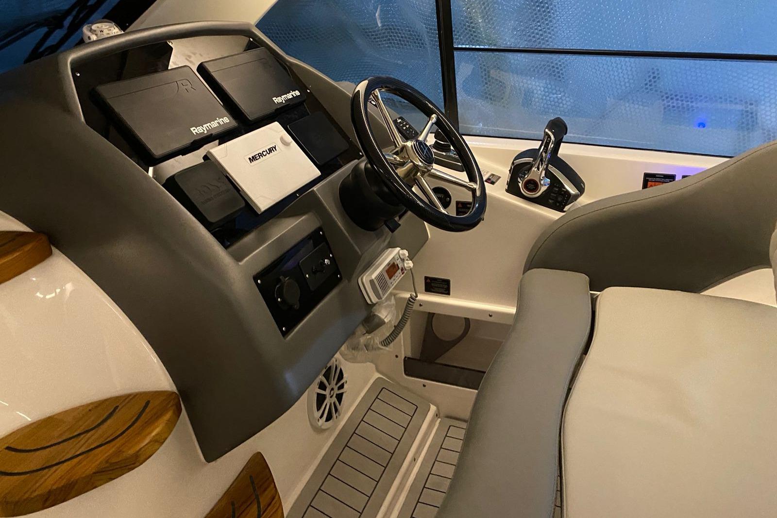Interior of 2026 Hanover 375 boat cockpit with steering wheel and navigation equipment.