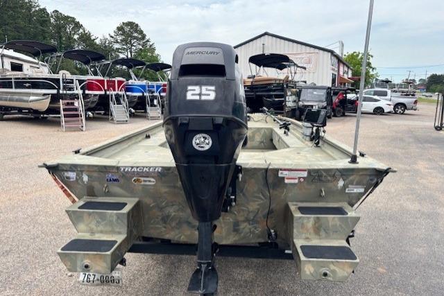 2017 Tracker Grizzly 1654 MVX Sportsman boat with Mercury 25 engine, parked outdoors.